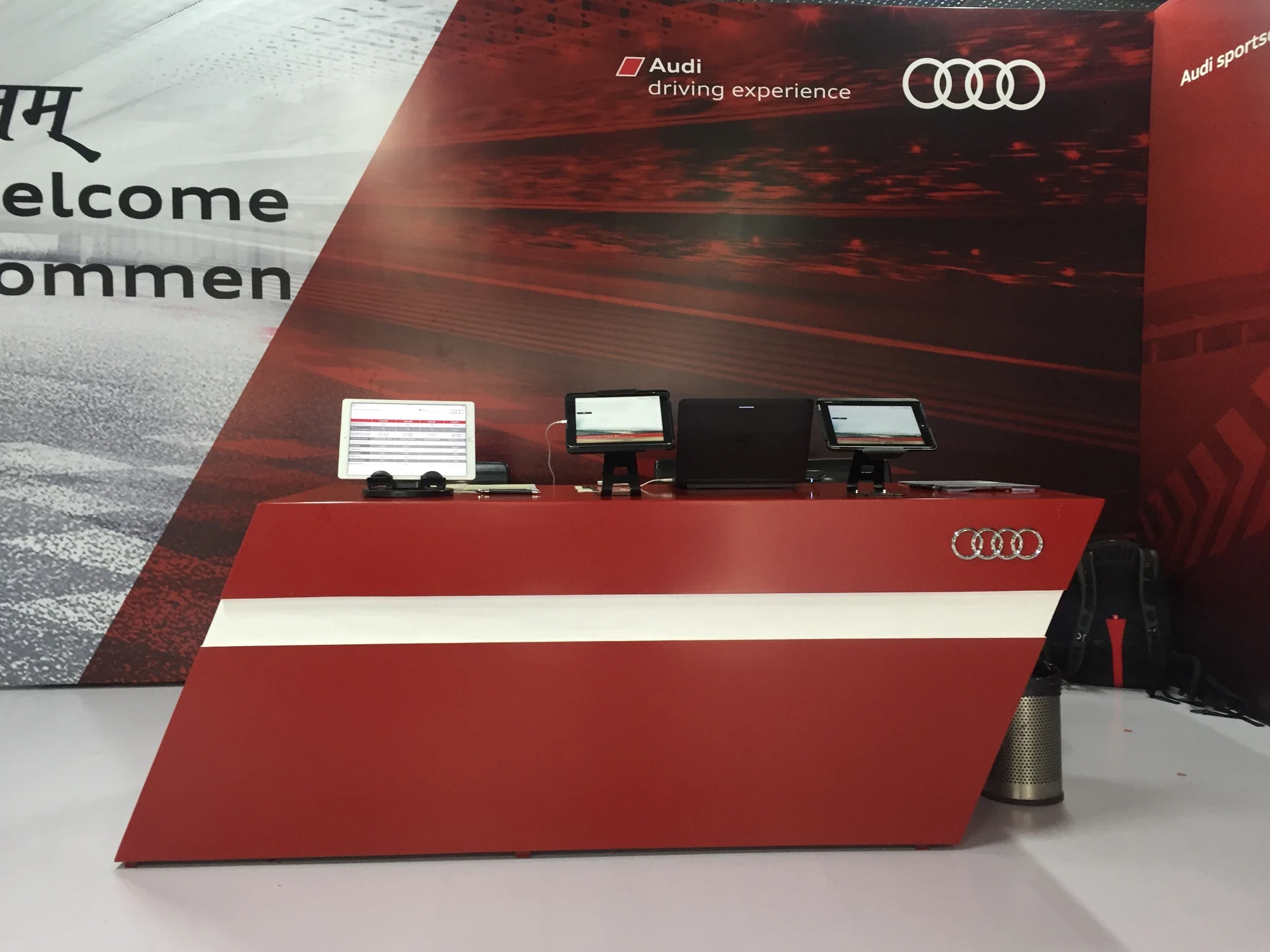 Audi driving experience registration counter in signature red with branded backdrop