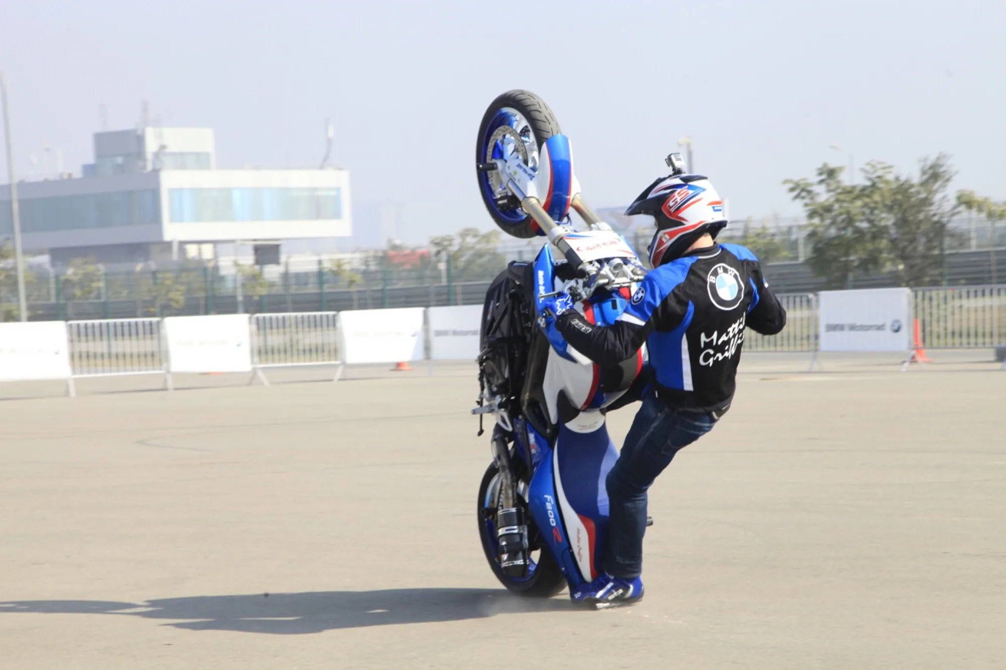 Stunt rider performing a vertical wheelie on a BMW motorcycle at the Motorrad experience