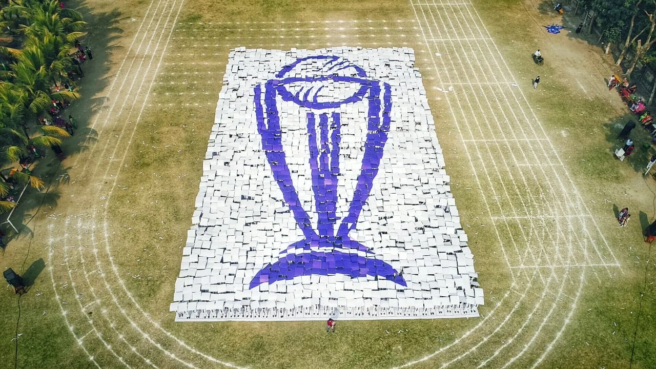 Aerial view of the giant ICC World Cup trophy card mosaic formed by participants on a field