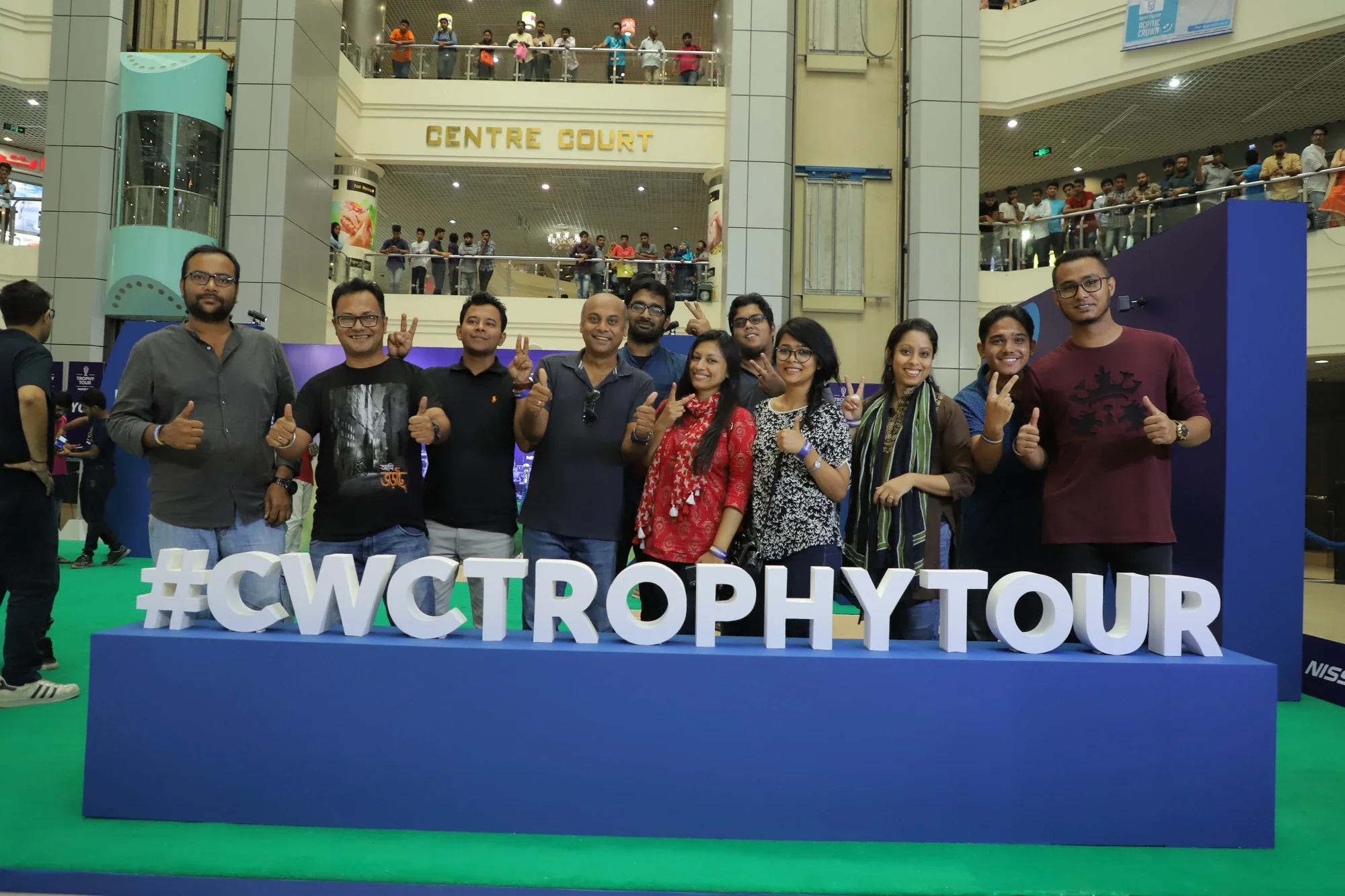 Trophy Tour team behind the giant #CWCTrophy letters at Centre Court mall