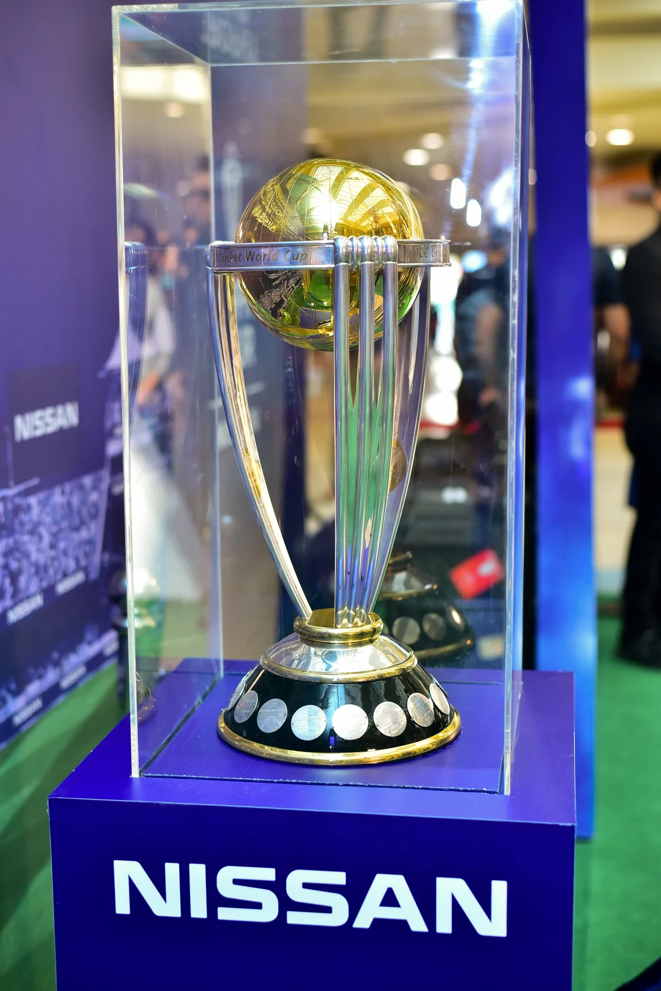 The ICC World Cup trophy in its display case with Nissan-branded plinth