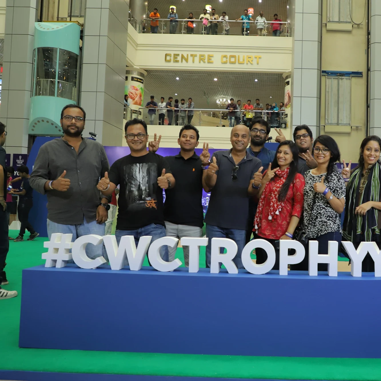 Trophy Tour team behind the giant #CWCTrophy letters at Centre Court mall