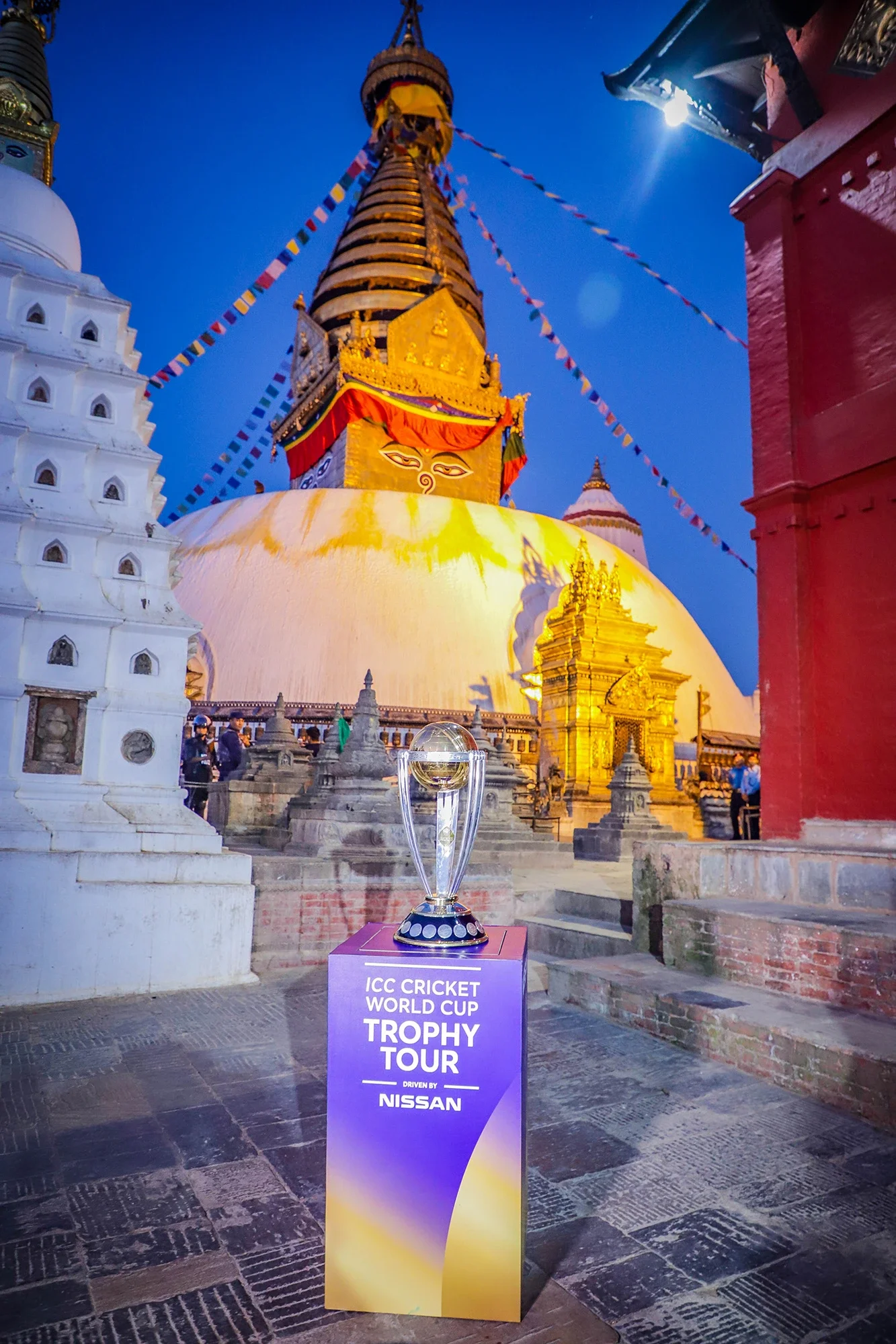 The ICC World Cup trophy against the illuminated Swayambhu stupa at dusk