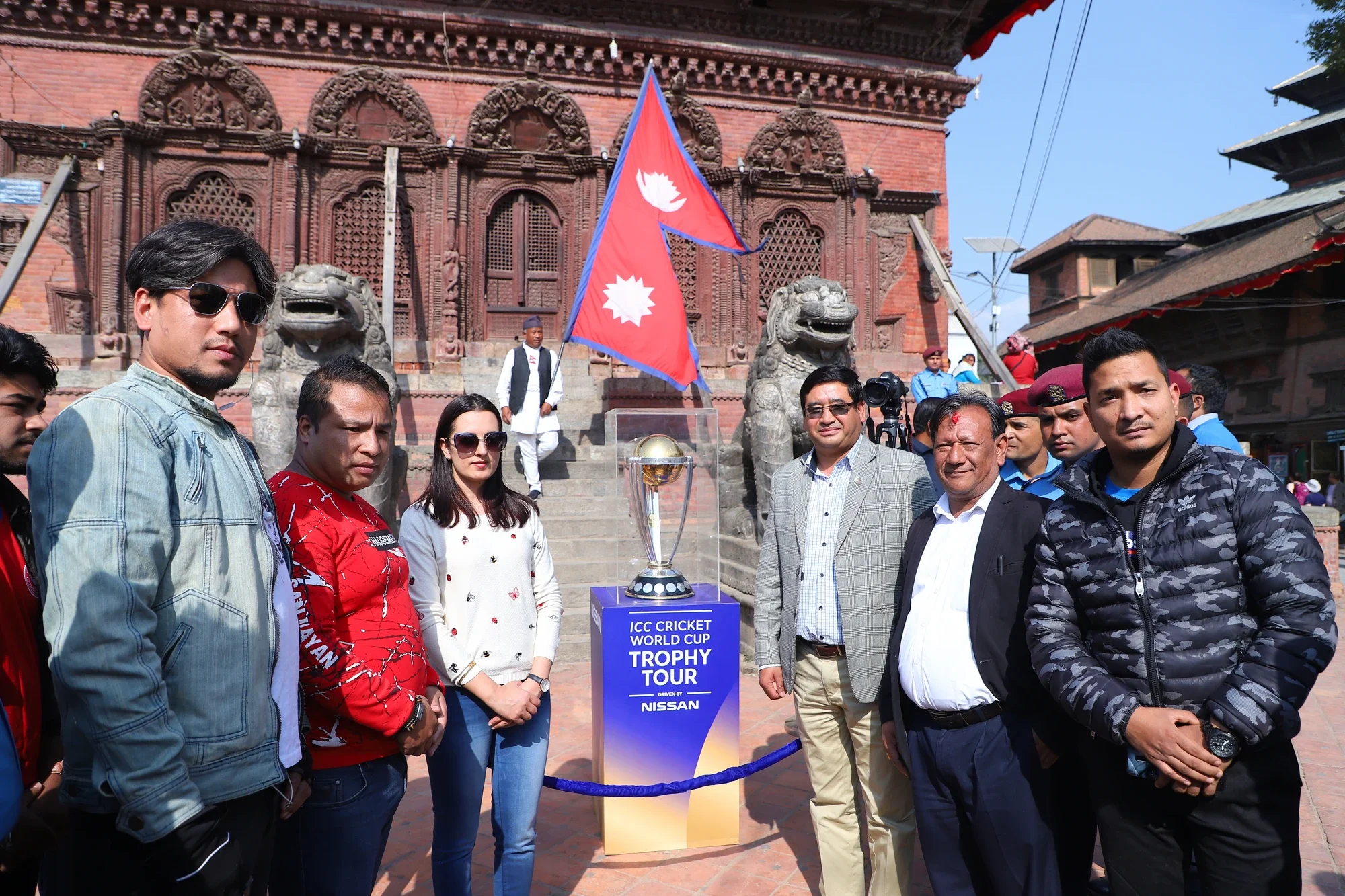 Officials with the trophy and the Nepal flag at the temple unveiling