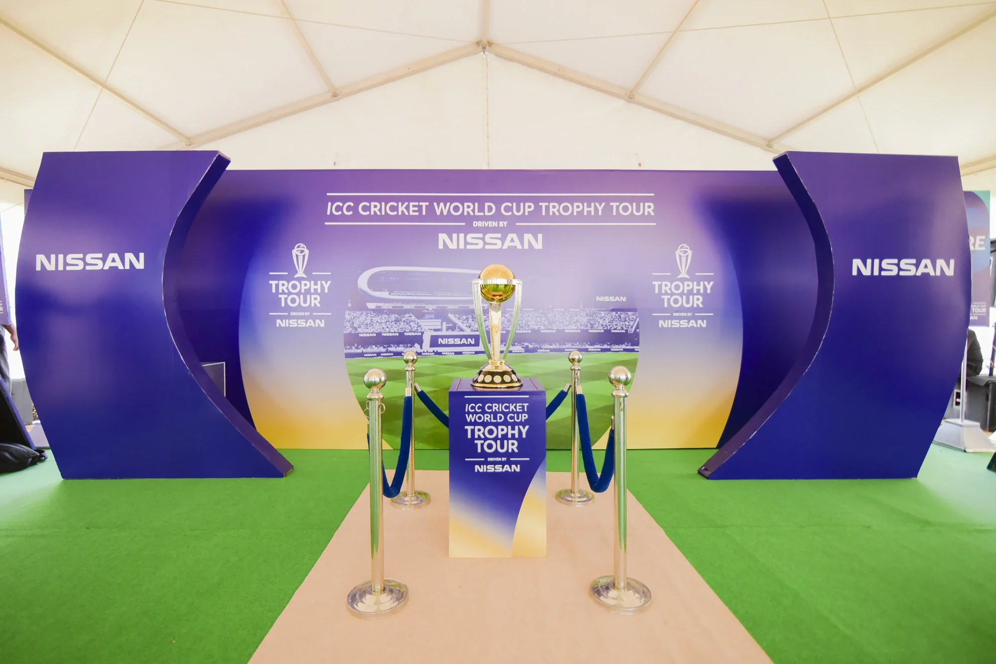 ICC Cricket World Cup trophy on display with Nissan branding and stanchions