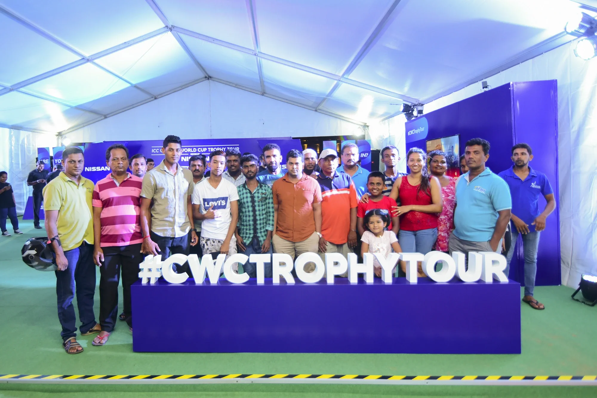 Fans posing behind the giant #CWCTrophyTour letters inside the tour marquee
