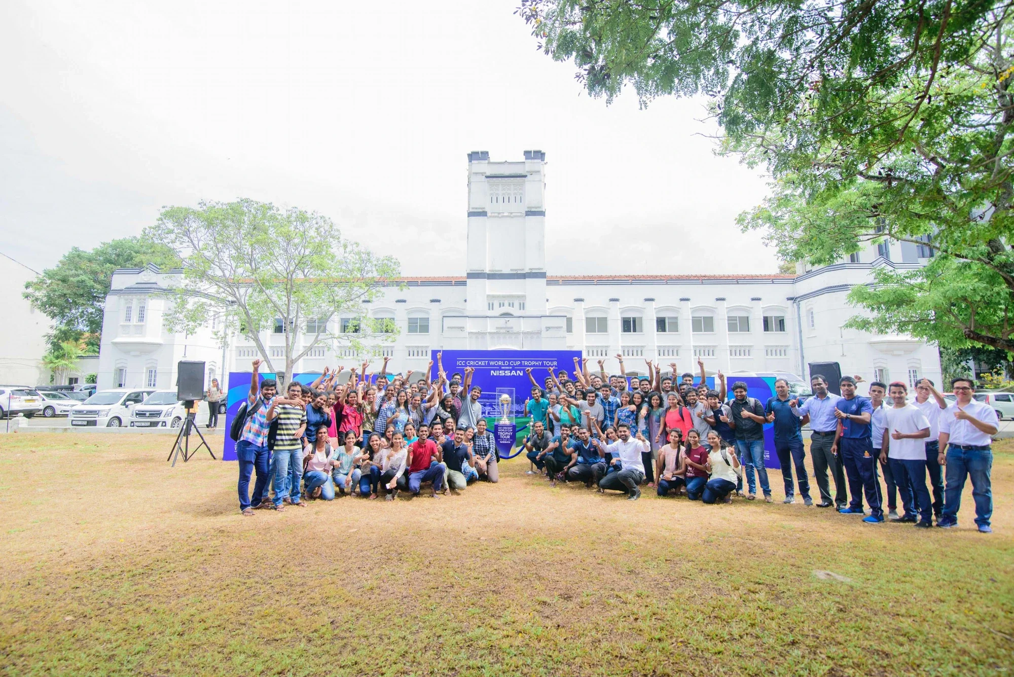 College students gathered for the Trophy Tour photo outside the campus building