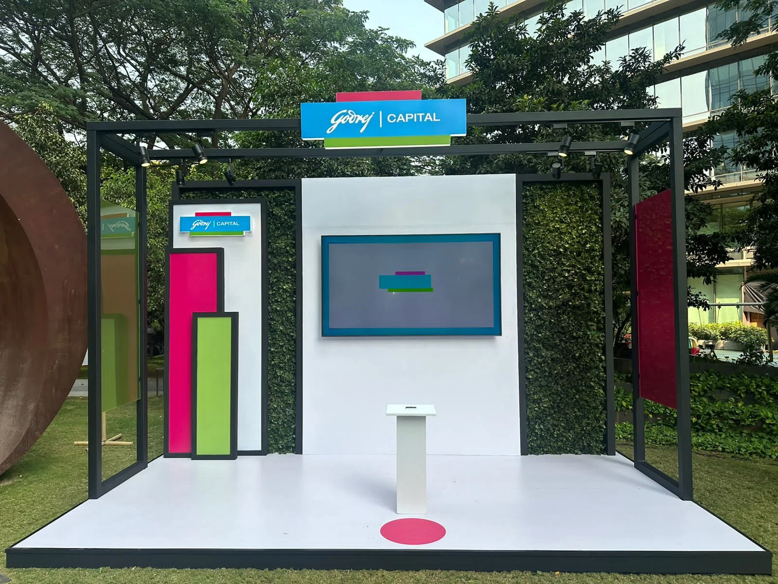 Godrej Capital interactive booth by day — game screen, colour-block panels and garden walls