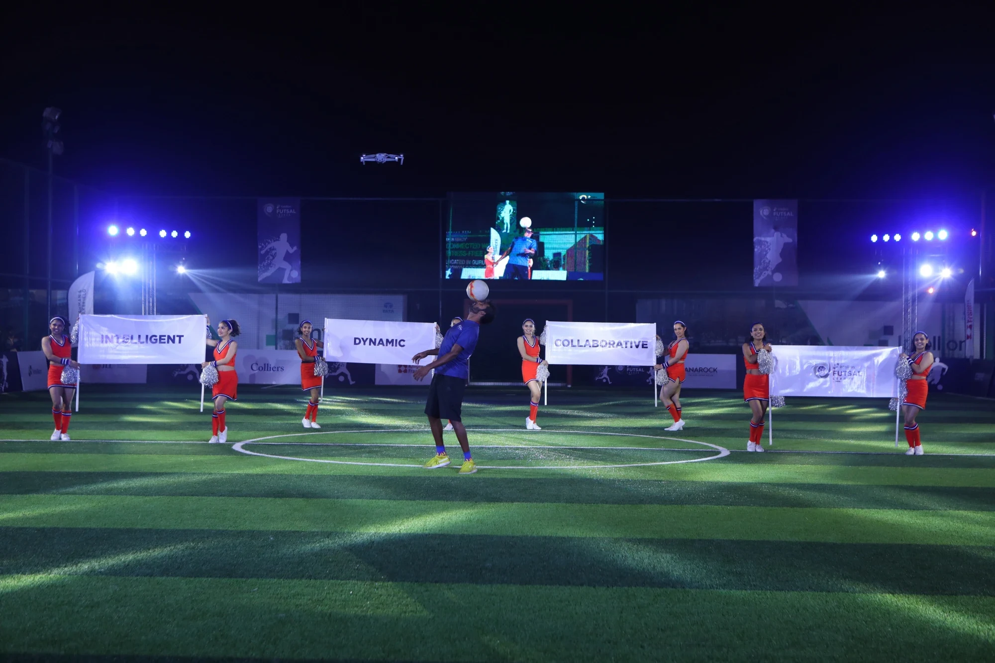 Freestyle footballer performing with cheerleaders at the Intellion Futsal League opening night