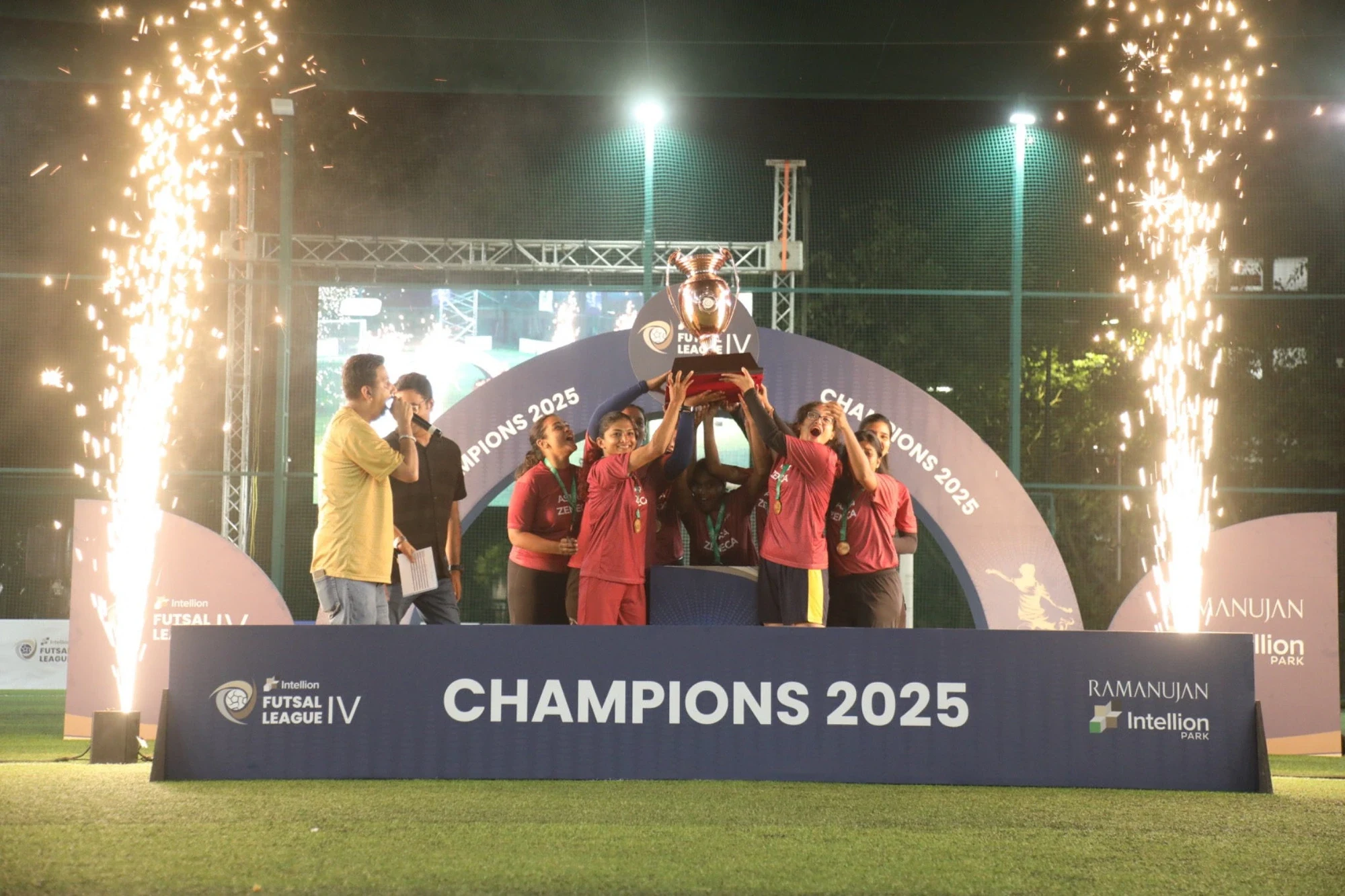 Women's champions lifting the trophy amid pyros at the Champions 2025 ceremony