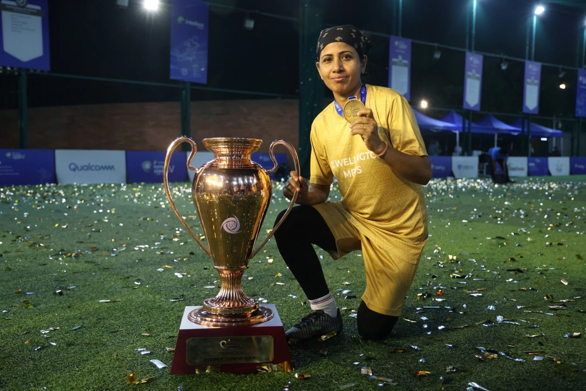Women's winner with her medal and the golden trophy on a confetti-strewn pitch, Chennai 2026