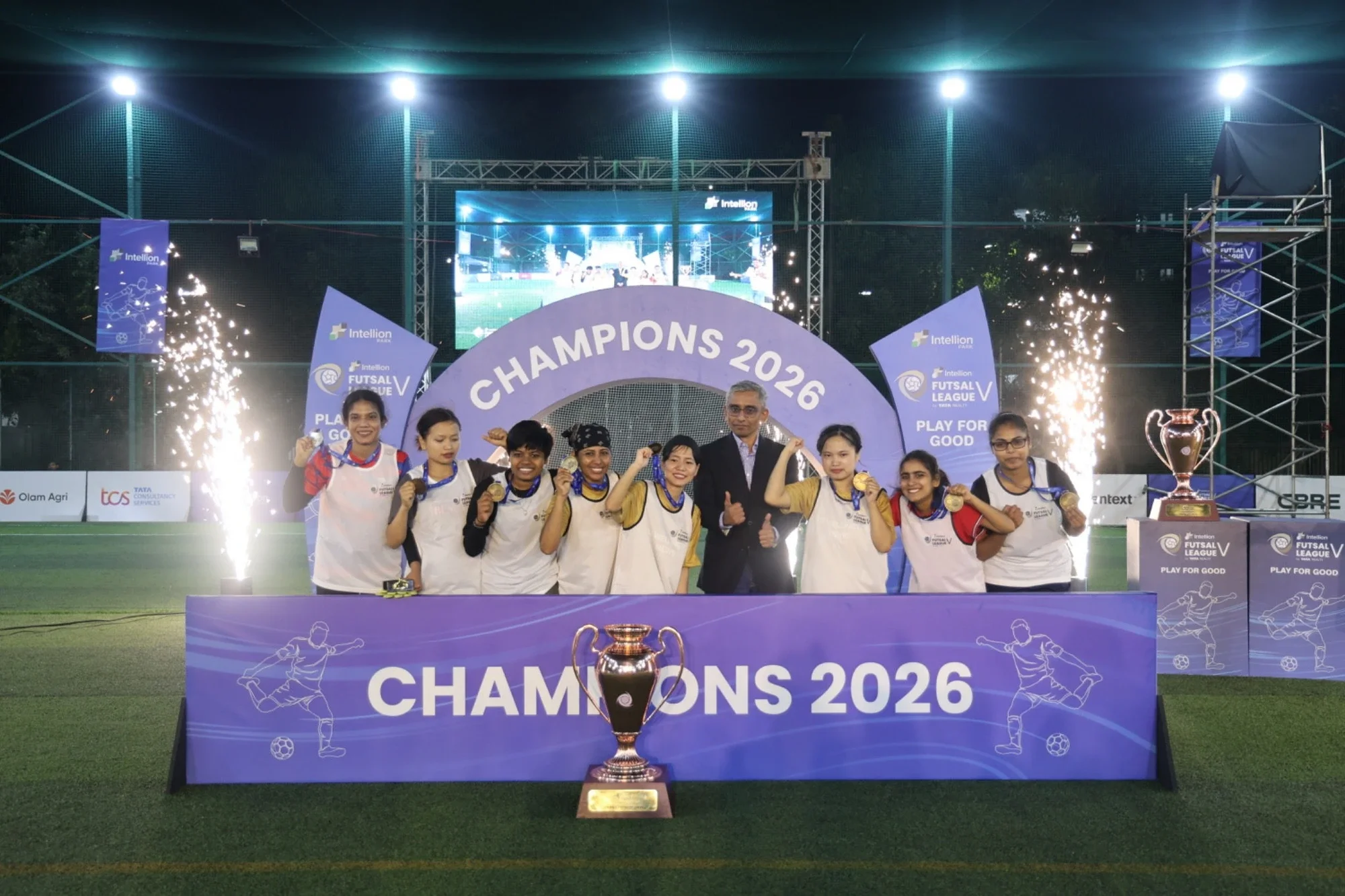 Champions 2026 — women's title winners on the podium with medals and pyros