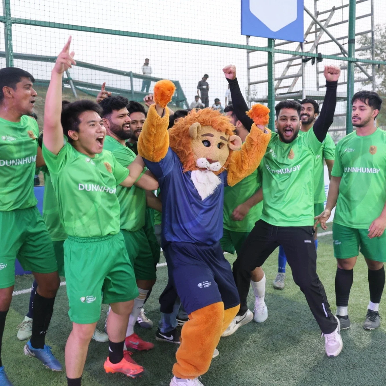 Dunnhumby team celebrating with Leo the mascot at Intellion Futsal League V