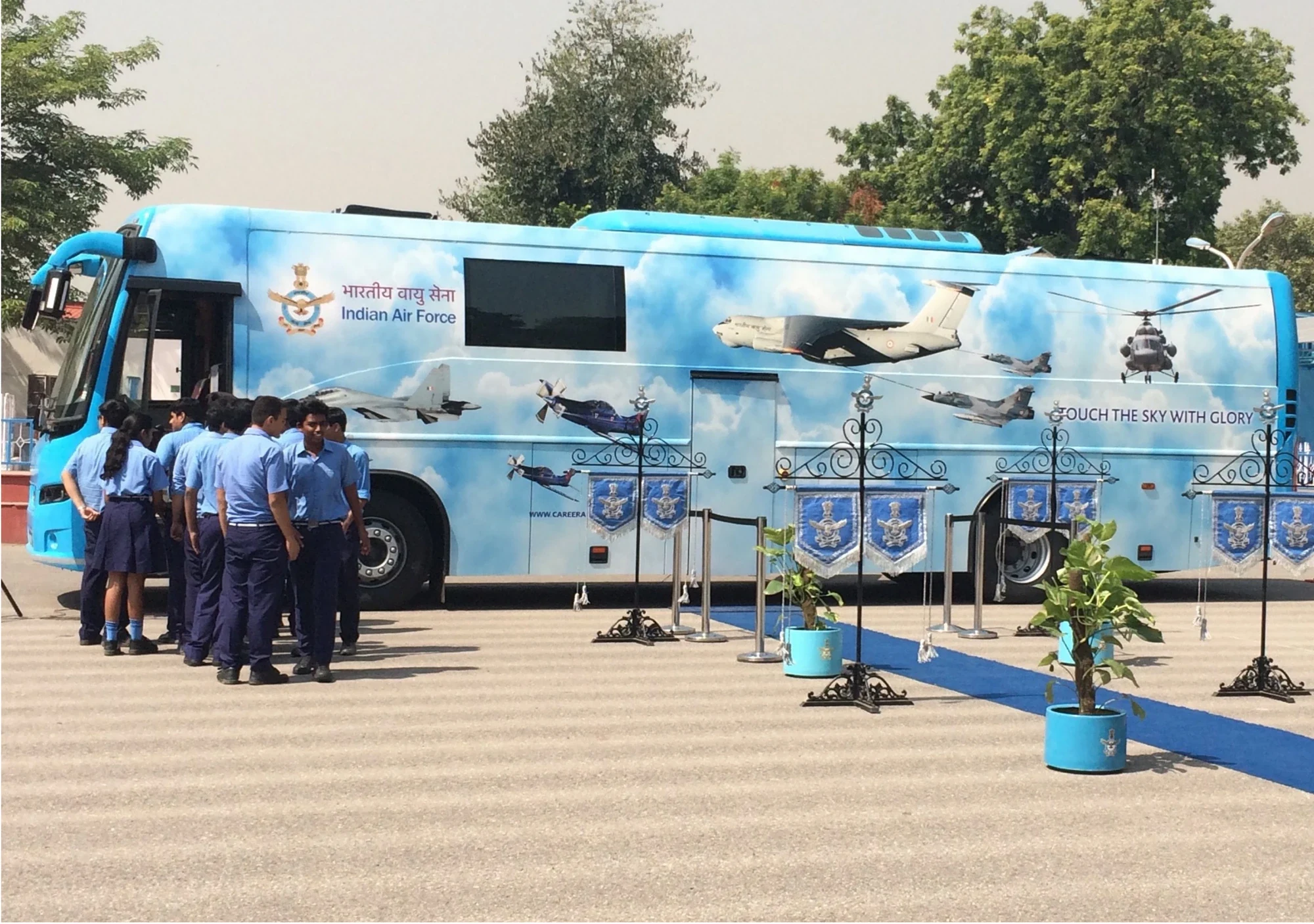 IAF Induction Publicity Exhibition Vehicle wrapped in sky livery with students queuing to board