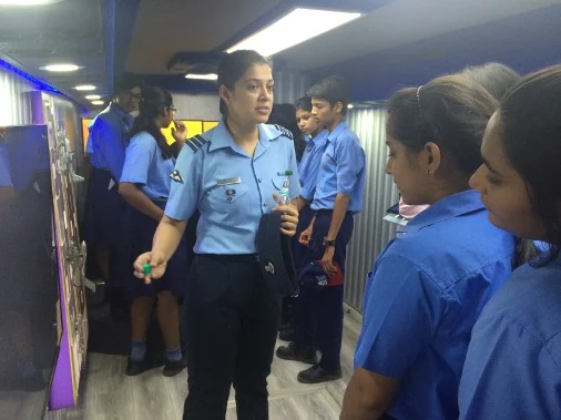 IAF officer guiding school students through the exhibition zones inside the vehicle