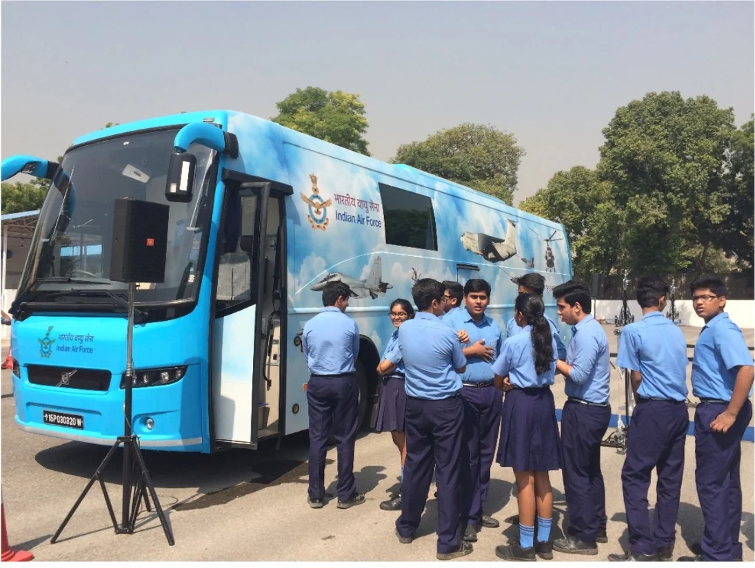 Front angle of the IAF exhibition bus with a group of aspirants gathered outside