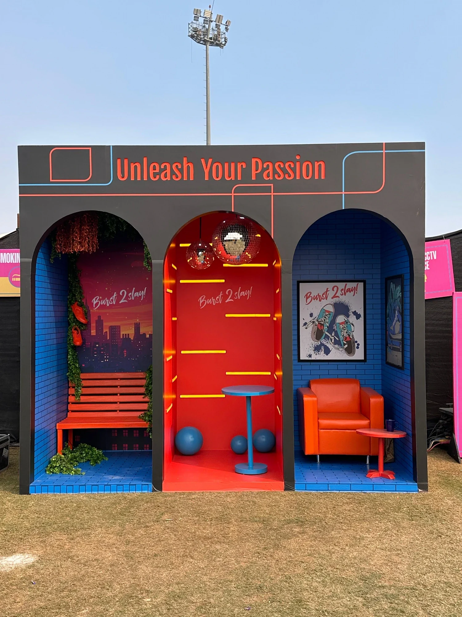 Front view of the ITC experiential zone — Burst 2 Slay rooms with disco balls and neon signage