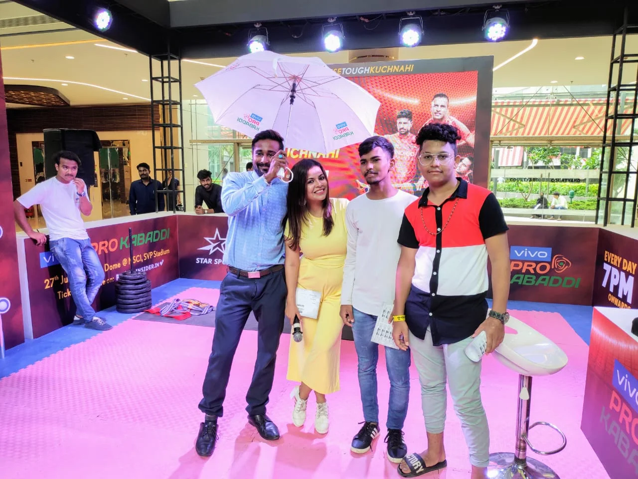 Winners celebrating with a vivo Pro Kabaddi branded umbrella on the pink activation court
