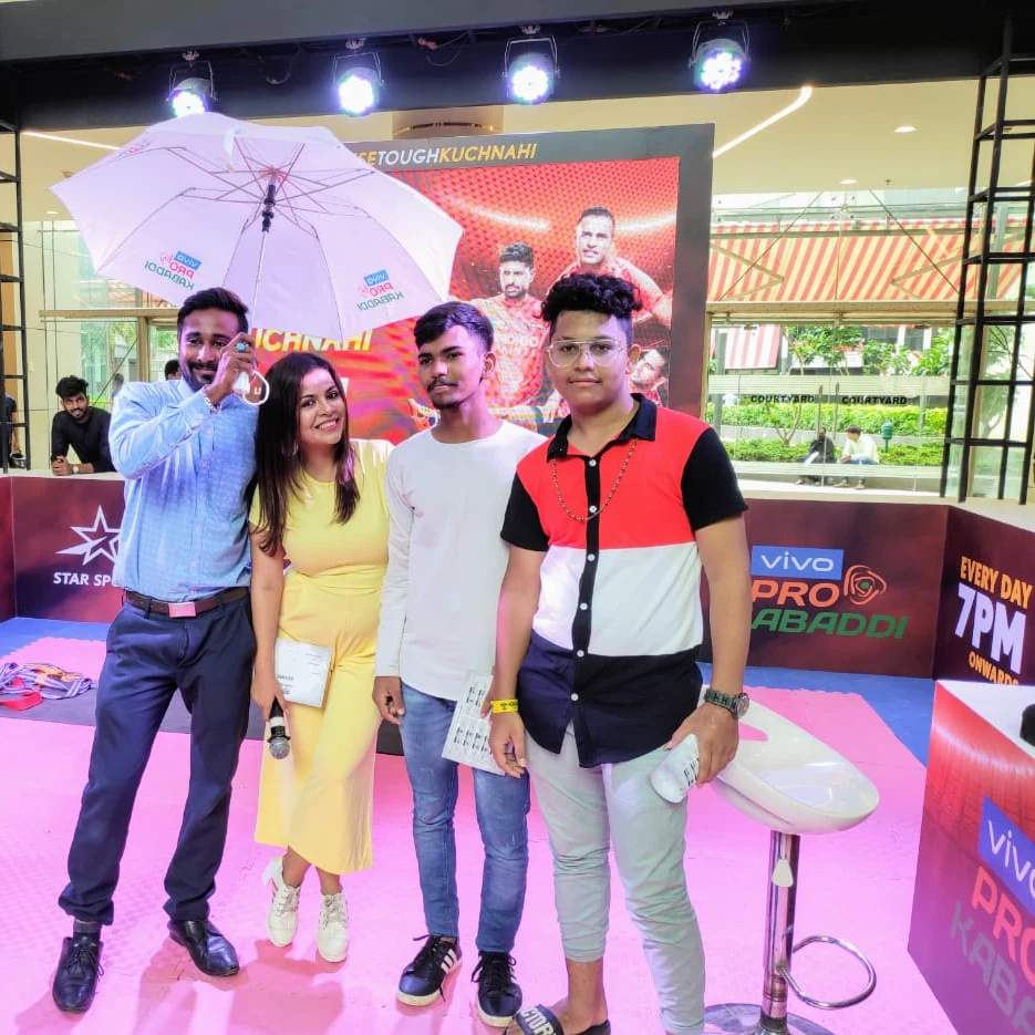 Winners celebrating with a vivo Pro Kabaddi branded umbrella on the pink activation court