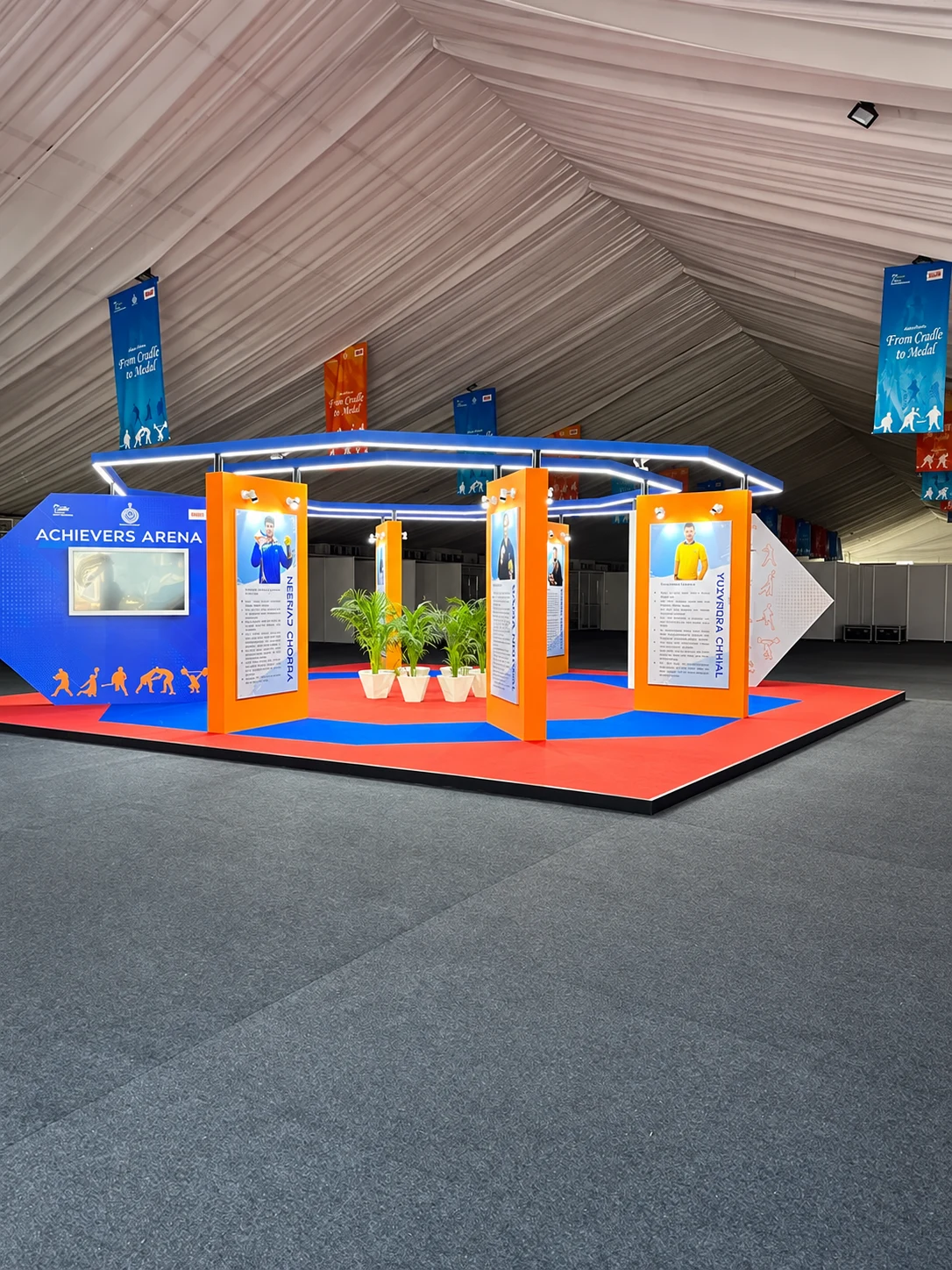 Achievers Arena — the Khelo India pavilion with athlete panels and From Cradle to Medal banners
