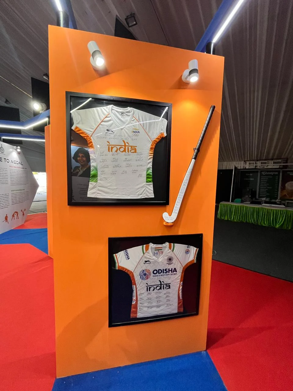 Framed Team India jerseys and hockey stick display at the Khelo India pavilion