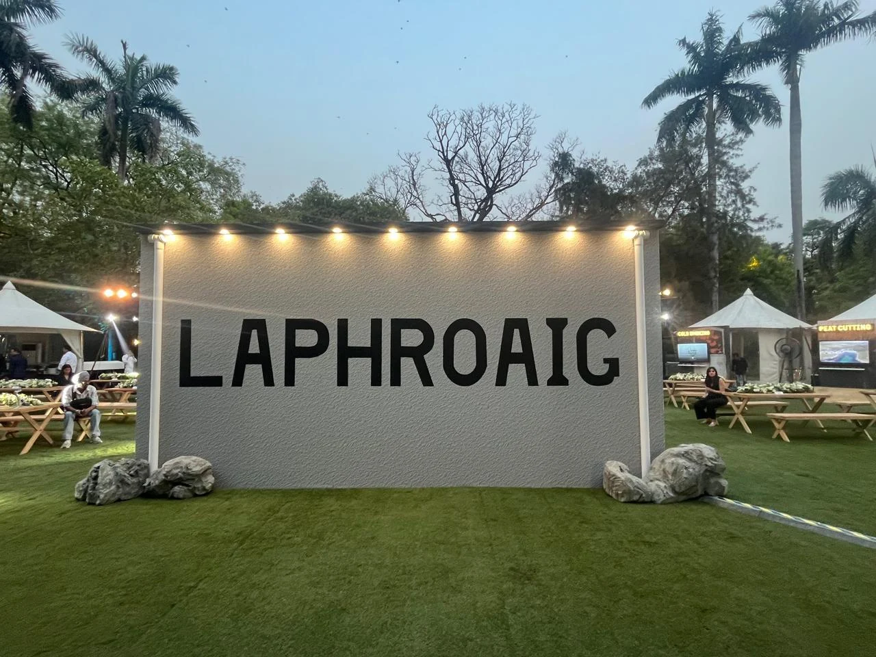 LAPHROAIG statement wall lit on the event lawn at dusk