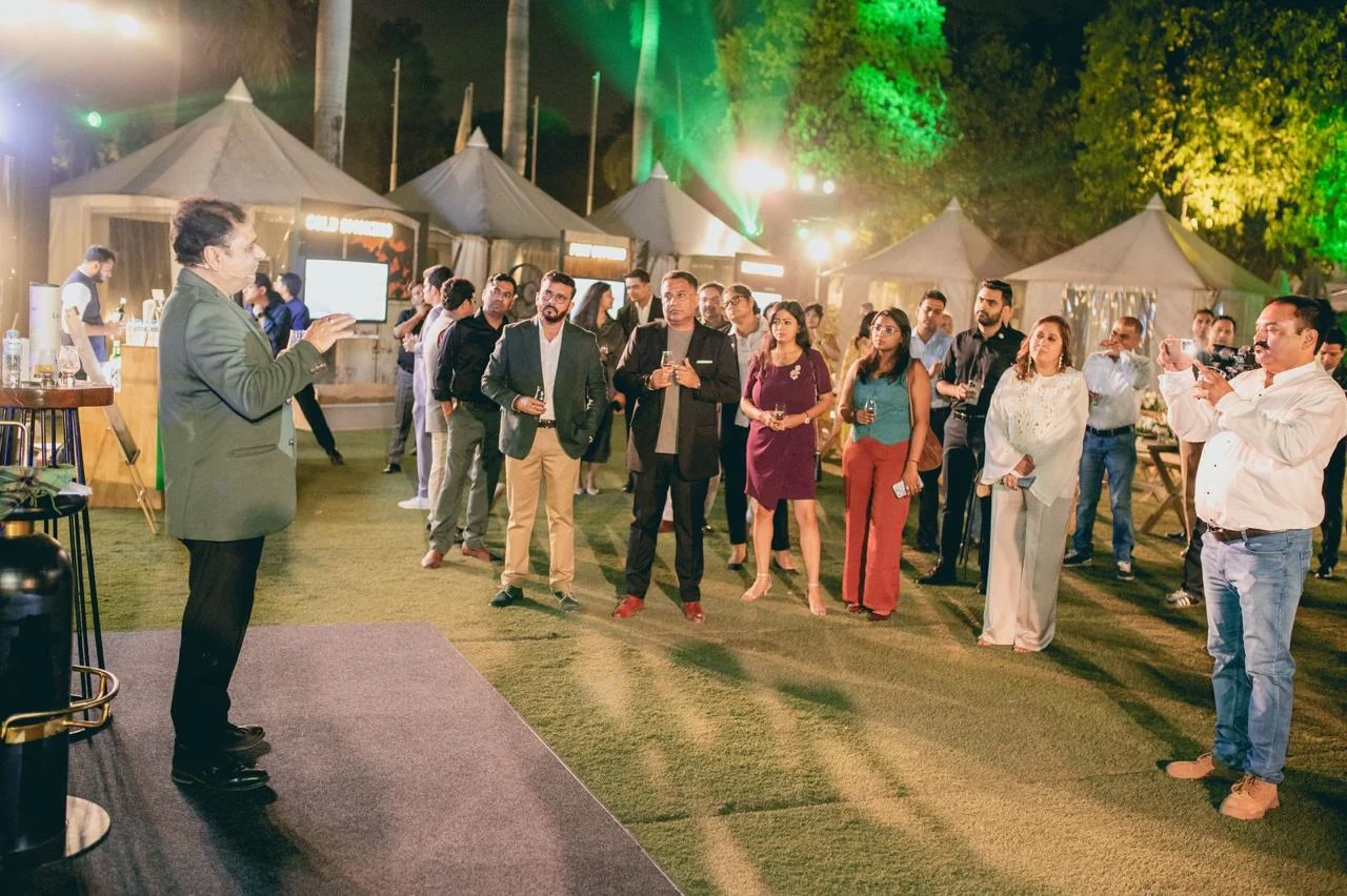 Brand host addressing guests with drams in hand at the evening soirée