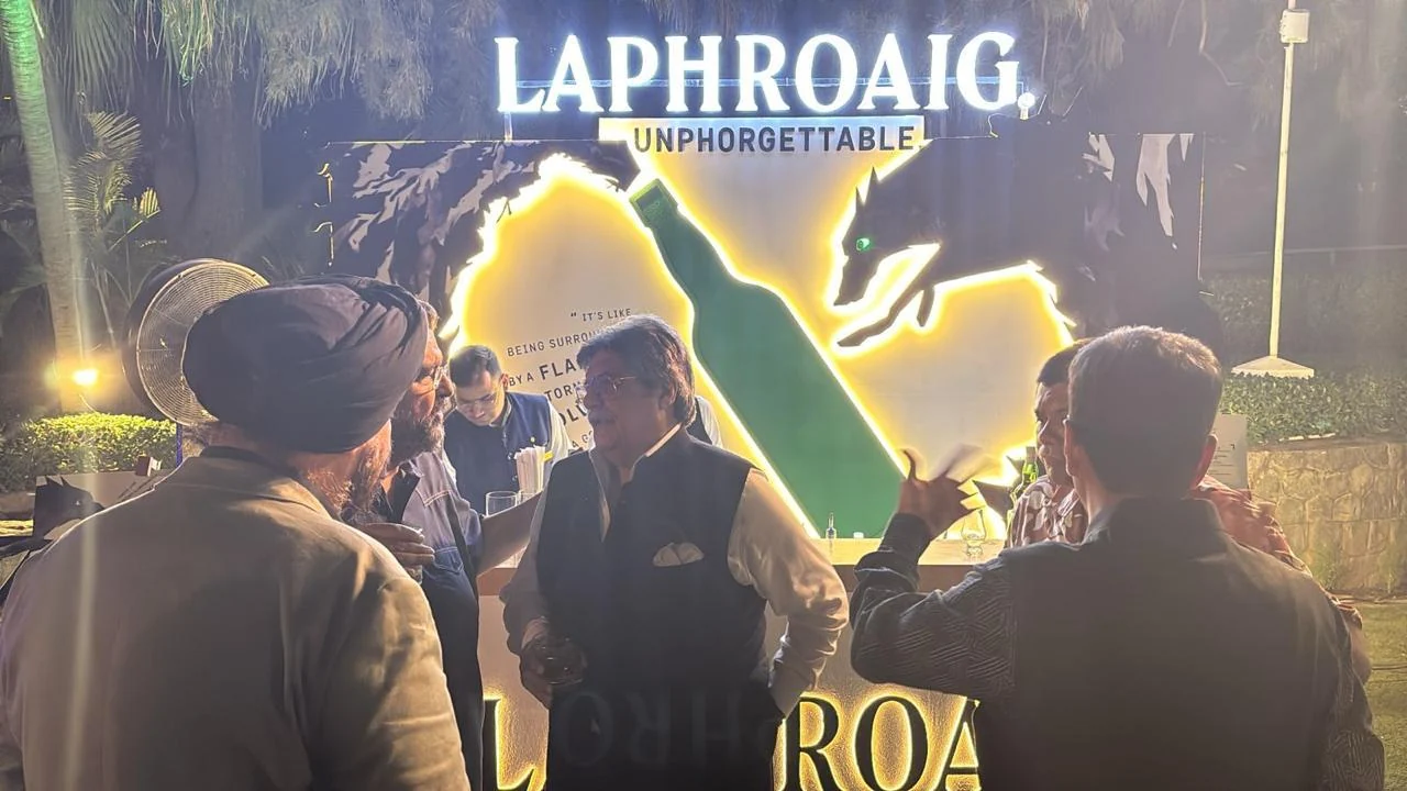 Guests gathered at the glowing Unphorgettable bar installation at night