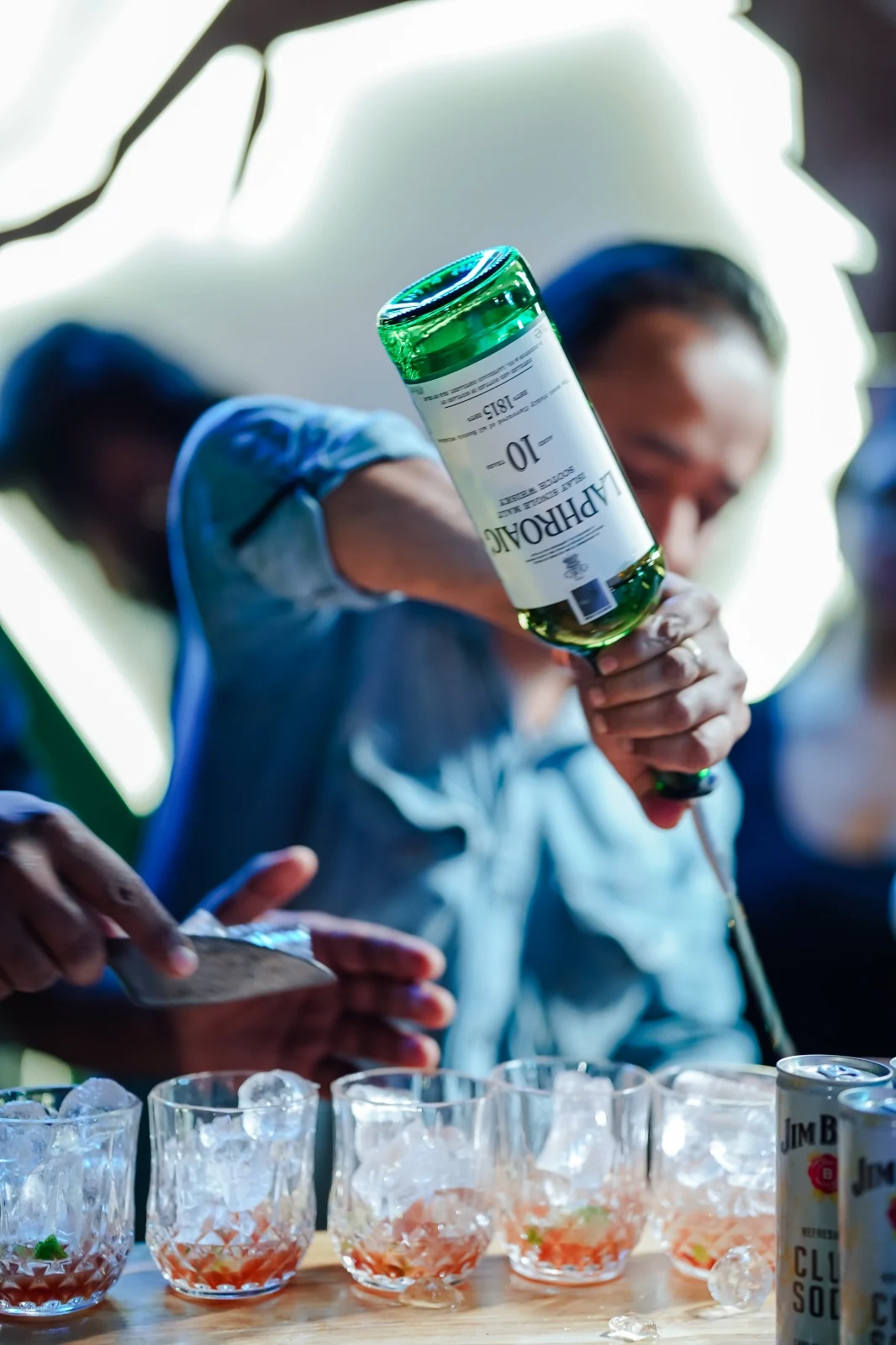 Laphroaig 10 poured over cocktails lined up on the bar