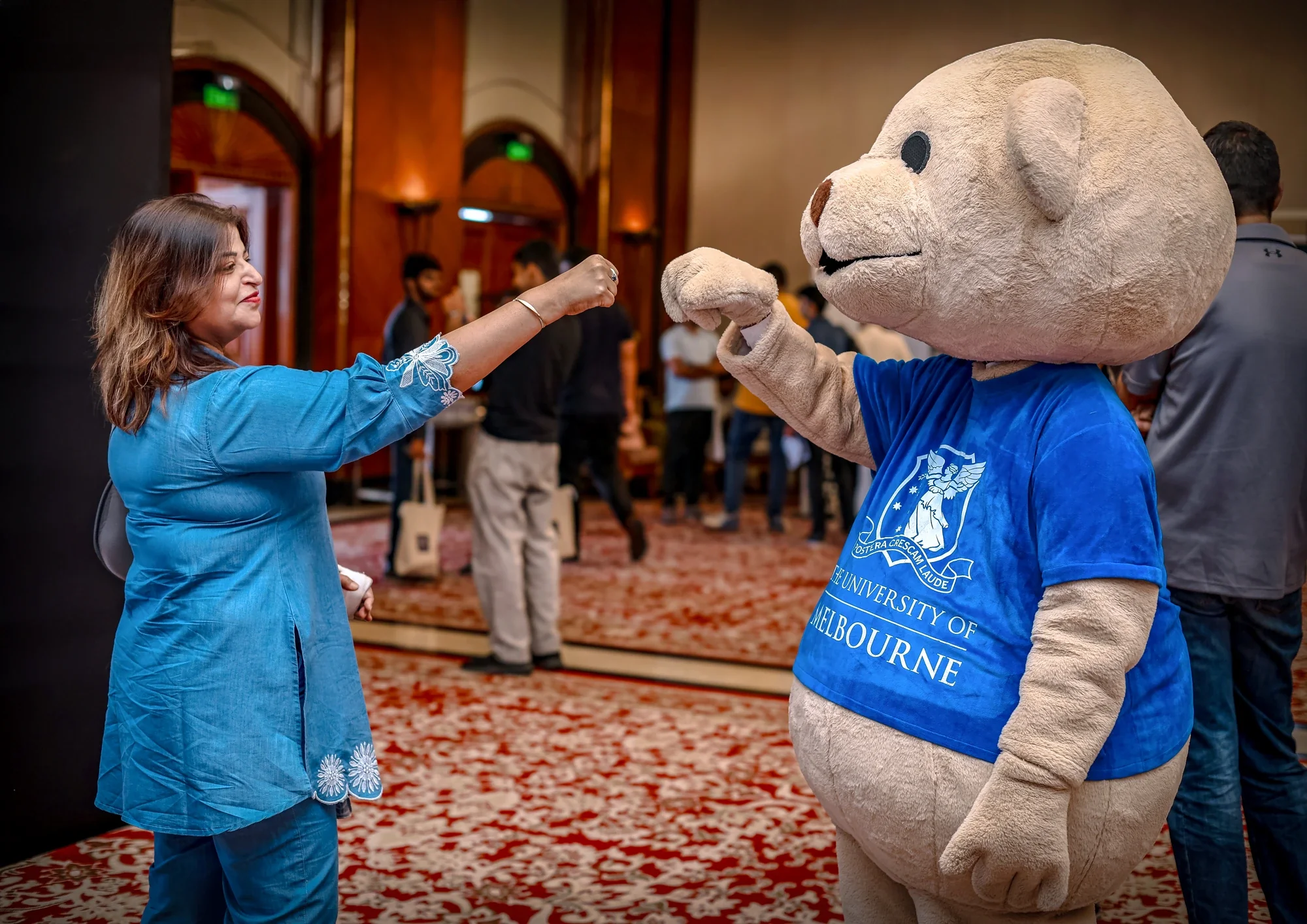 Guest fist-bumping the University of Melbourne mascot bear