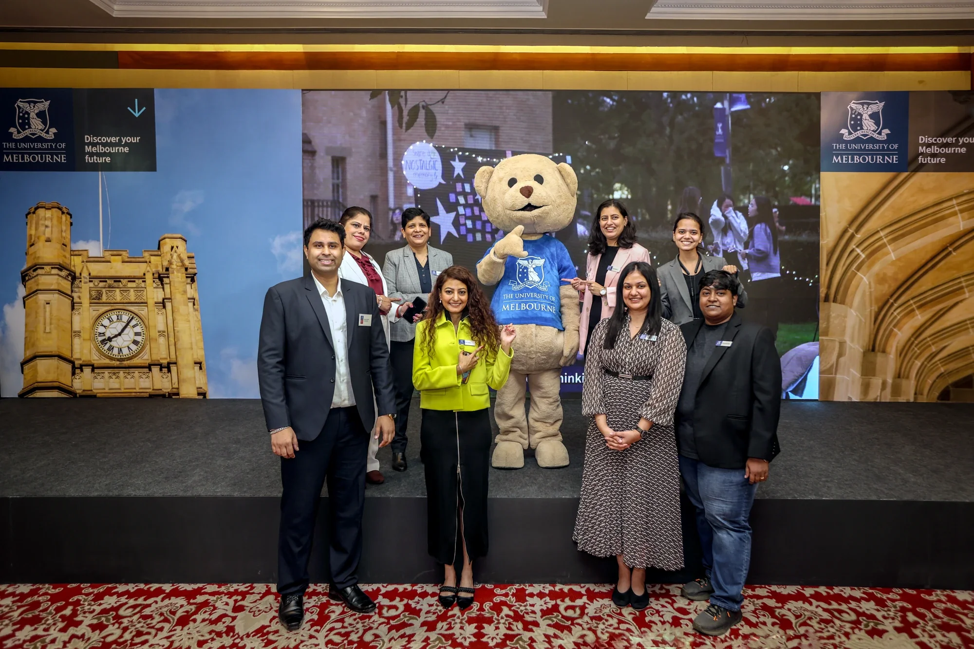 University of Melbourne team with the mascot bear on stage at the India roadshow