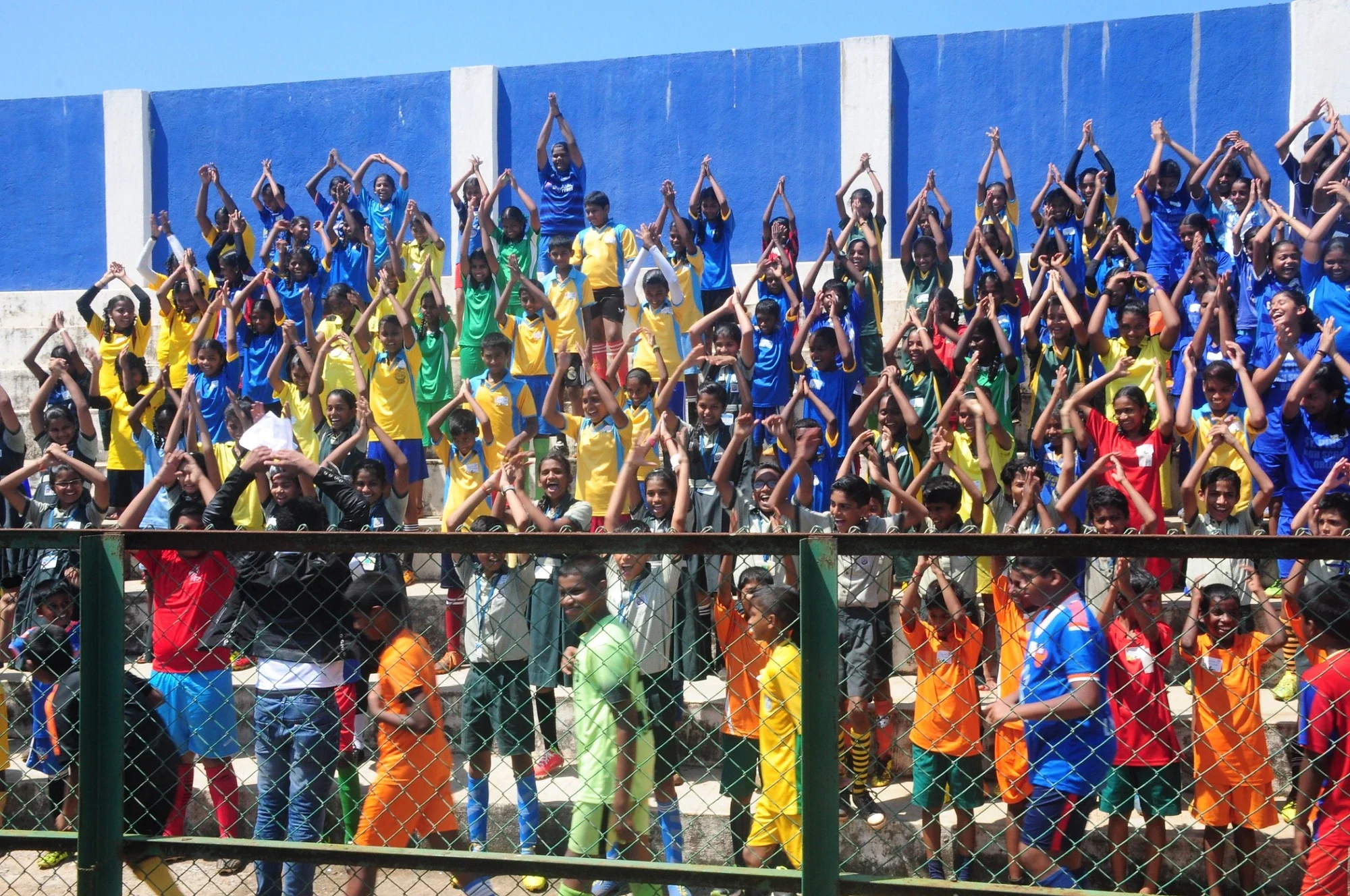 Children cheering from the stands at a Mission Eleven Million football carnival