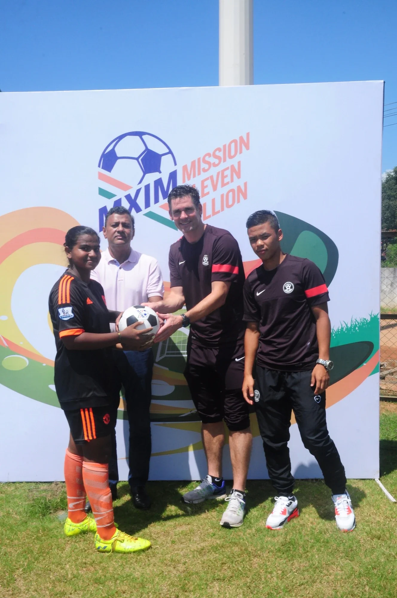 Football handover at the MXIM Mission Eleven Million branded backdrop
