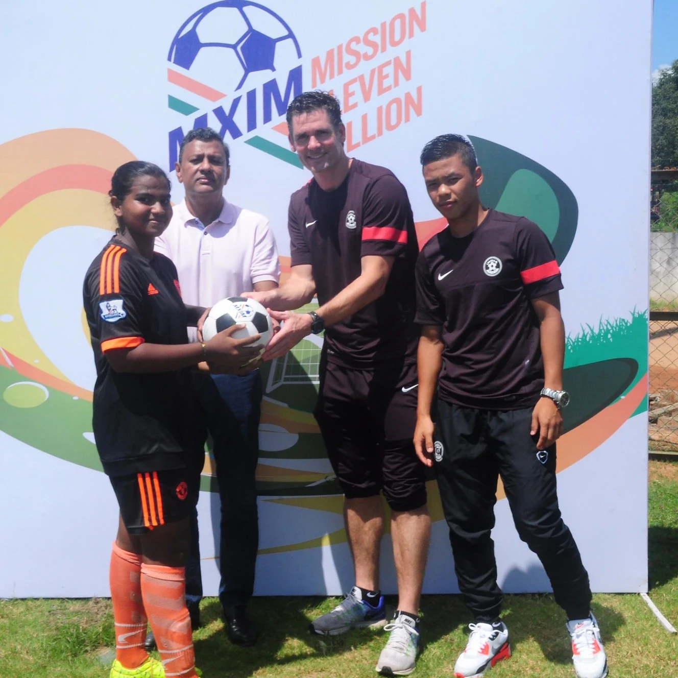 Football handover at the MXIM Mission Eleven Million branded backdrop