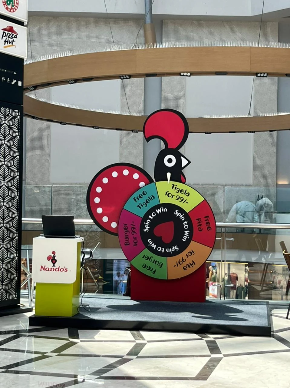 Nando's Spin to Win rooster wheel installation on the mall atrium floor