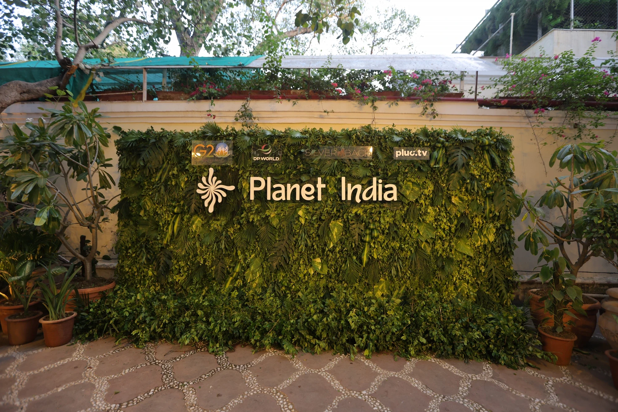 Planet India living green wall with partner logos at the Bikaner House entrance