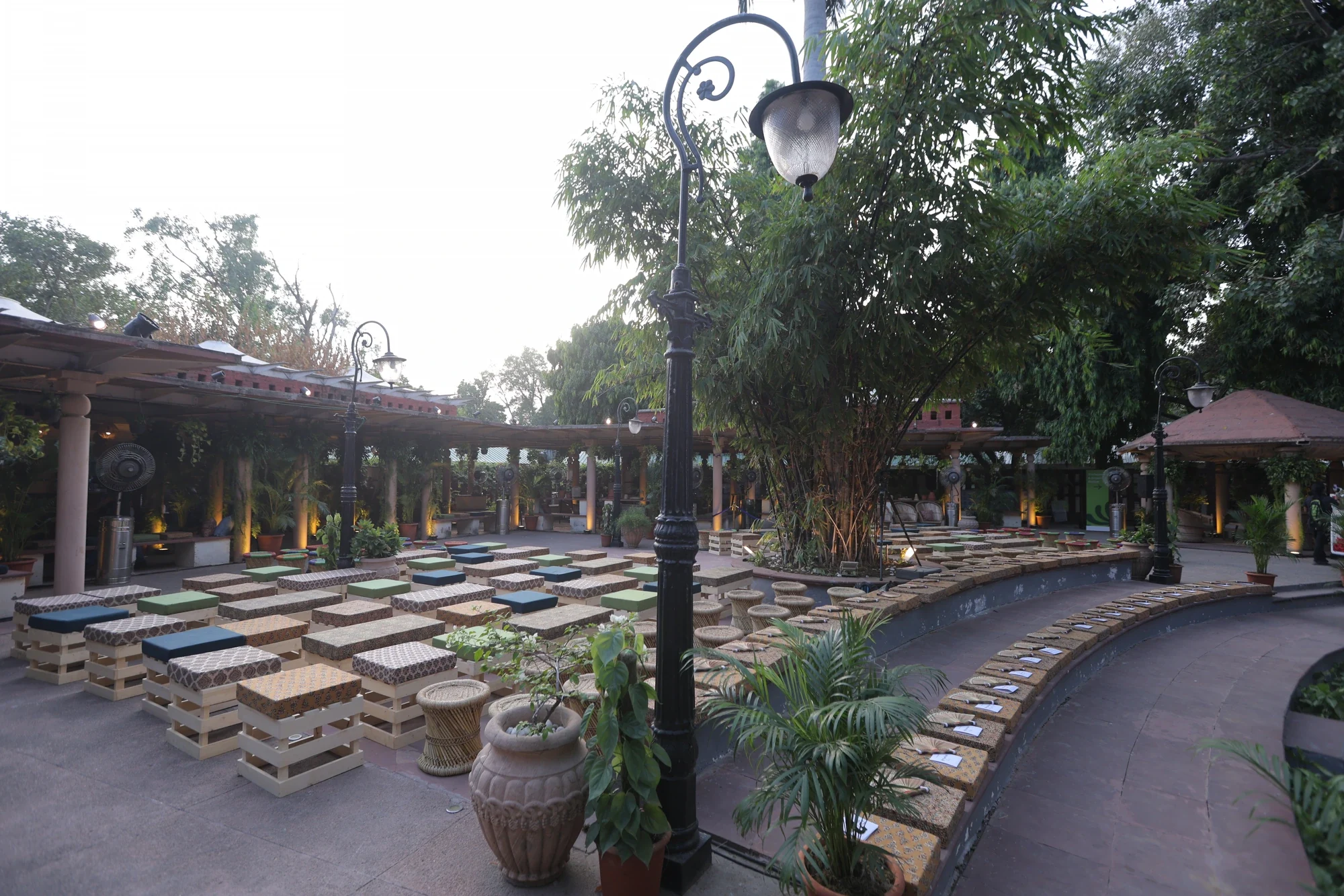 Garden amphitheatre set with pallet seating and lamp posts ahead of the evening