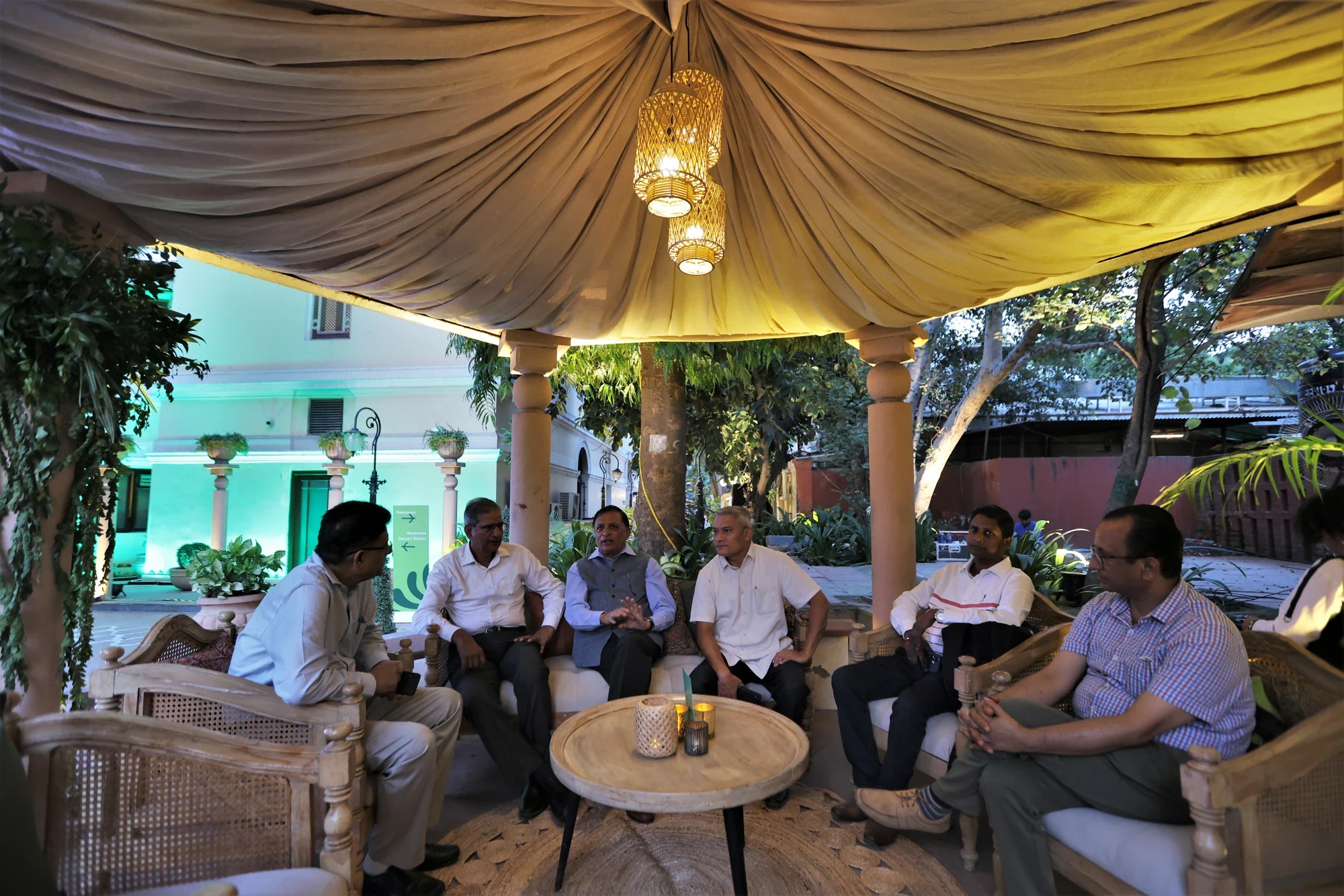 Delegates in conversation under the draped canopy lounge at Bikaner House