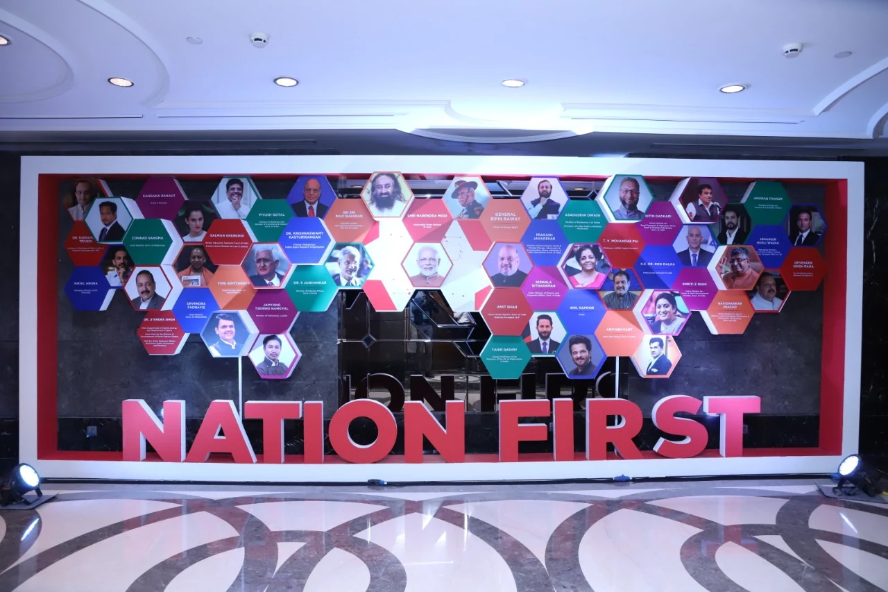 Nation First installation — hexagon wall of summit speaker portraits in the foyer