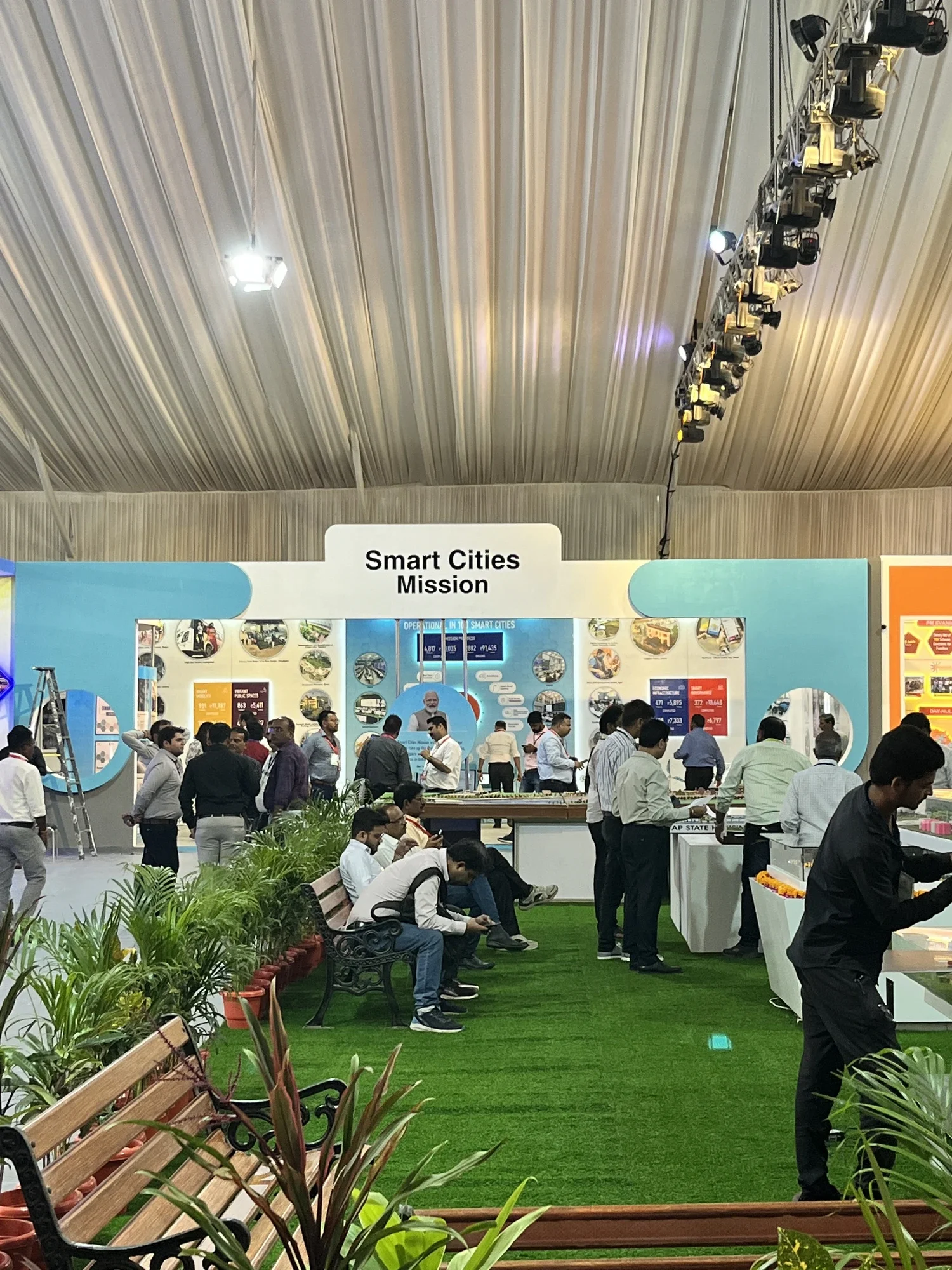 Visitors exploring the Smart Cities Mission pavilion from the lawn seating area