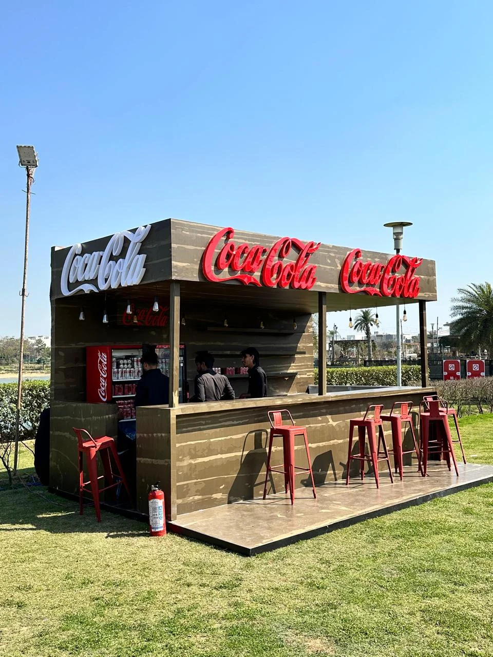 Coca-Cola bar counter with red stools serving festival guests