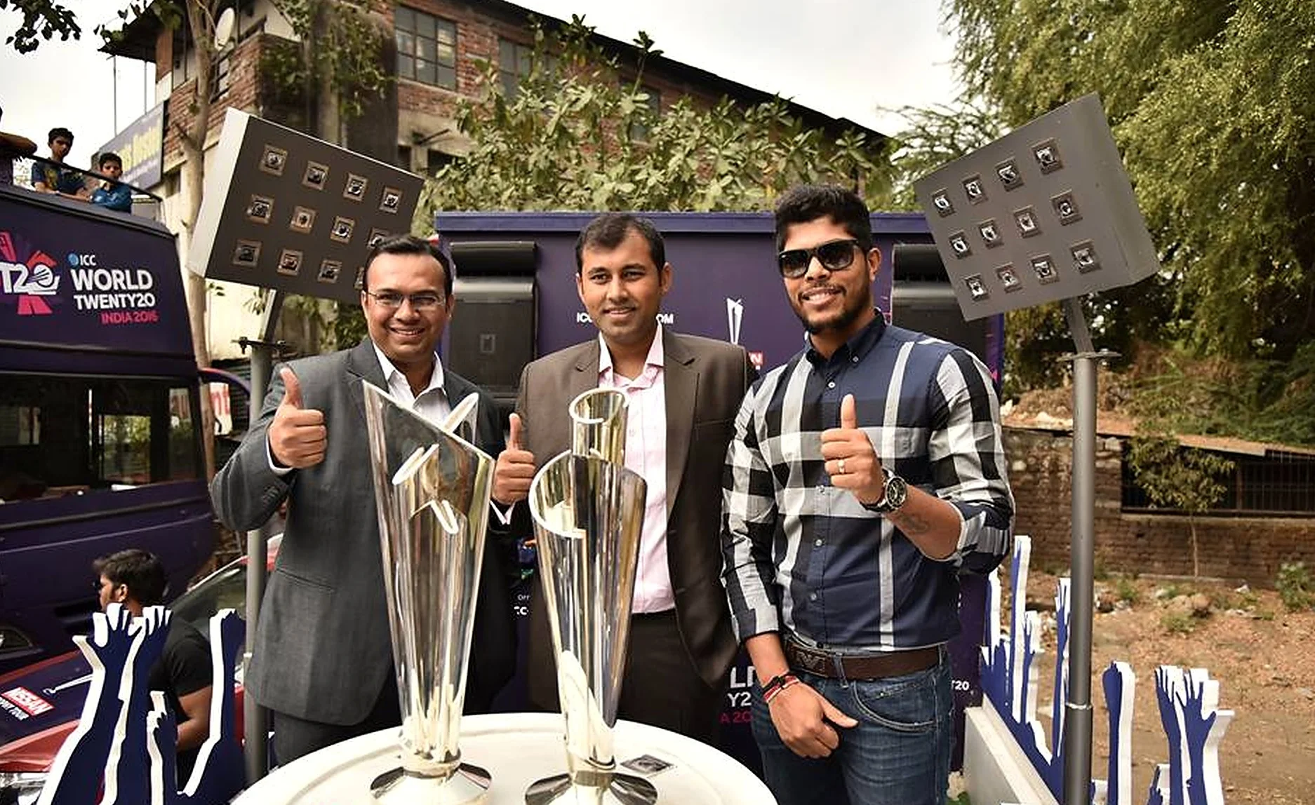 ICC World Twenty20 India 2016 trophy display with cricketer and officials giving a thumbs up