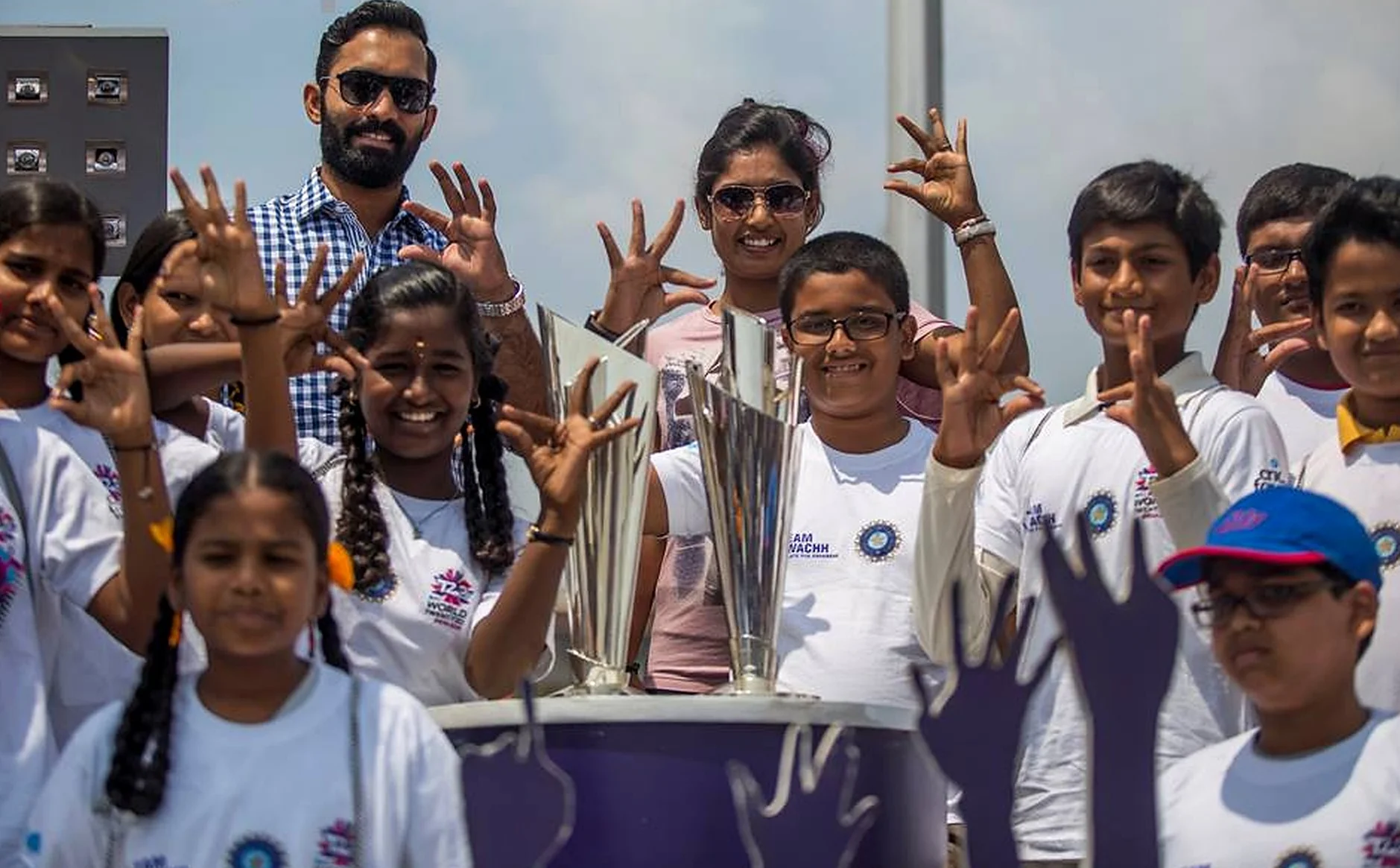 Schoolchildren cheering with the ICC World Twenty20 trophy aboard the tour bus