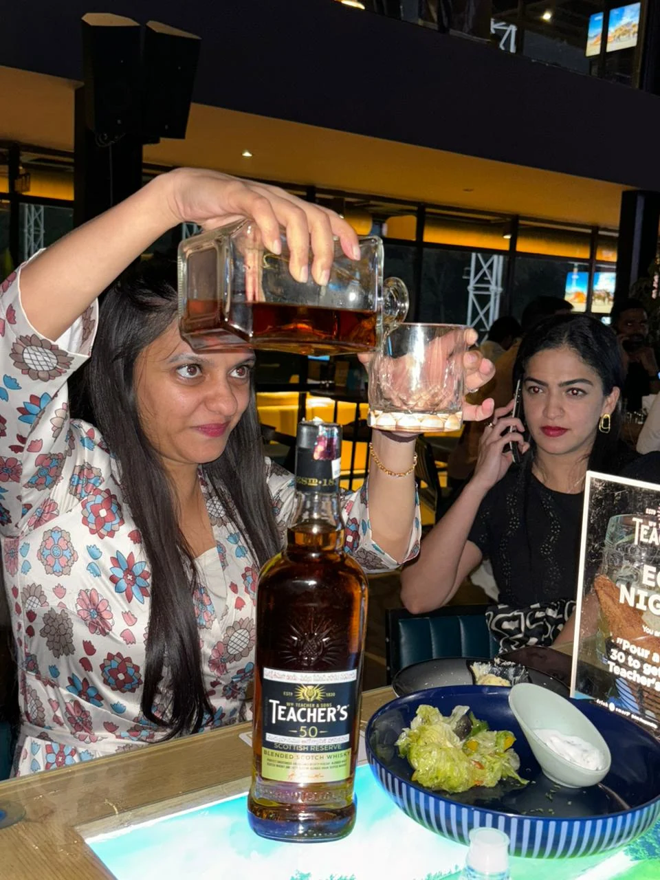 Guest pouring her own Teacher's 50 serve at the table during EOD Nights