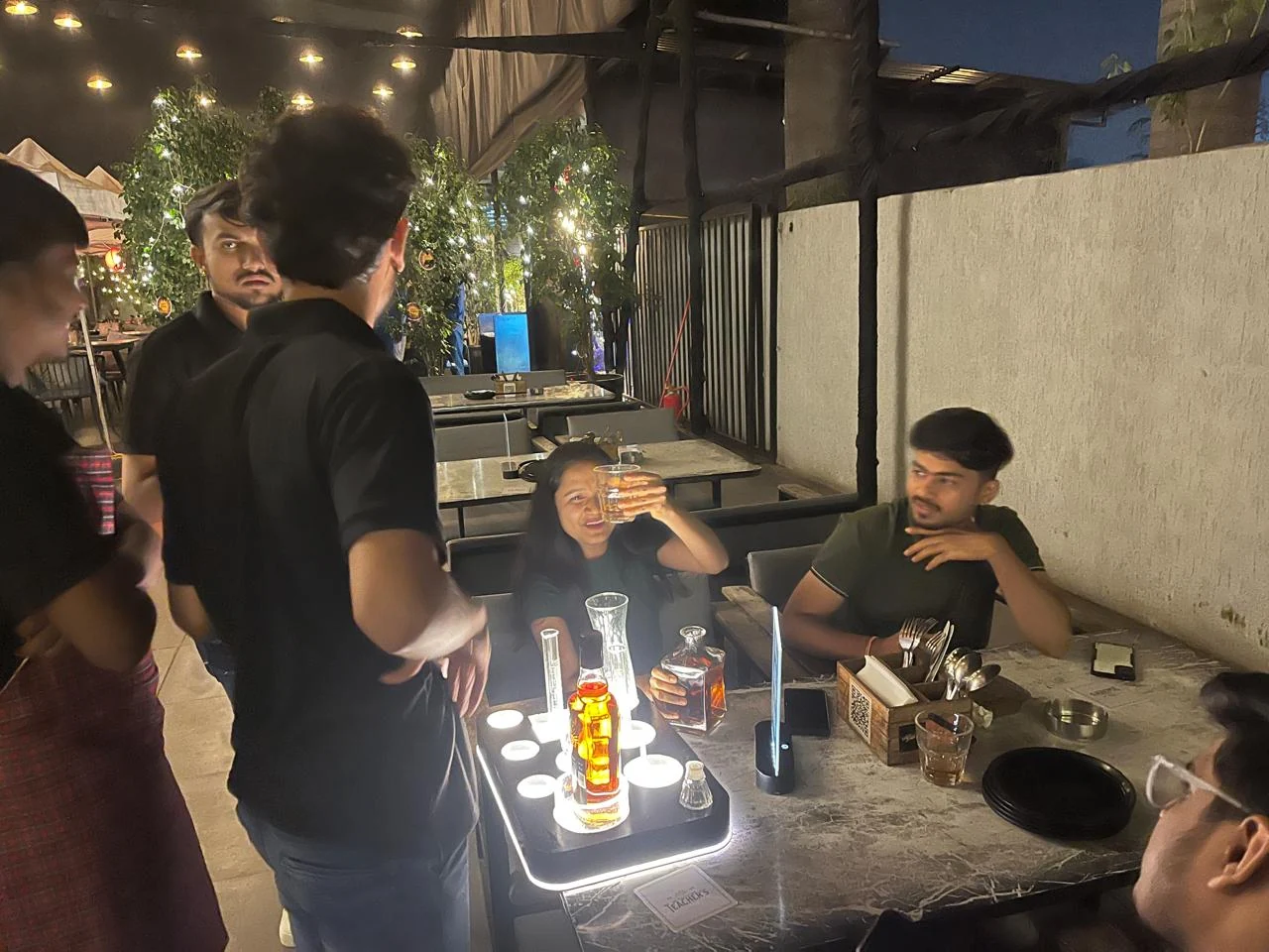 Guest raising a winning Teacher's pour at an outdoor resto-bar table