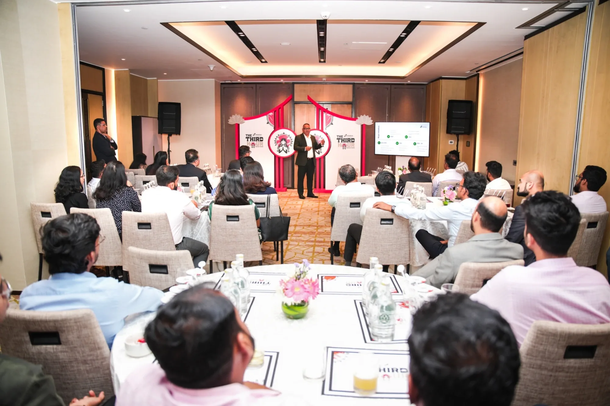 Host addressing IPC partners from The Third Hour branded stage at the networking dinner