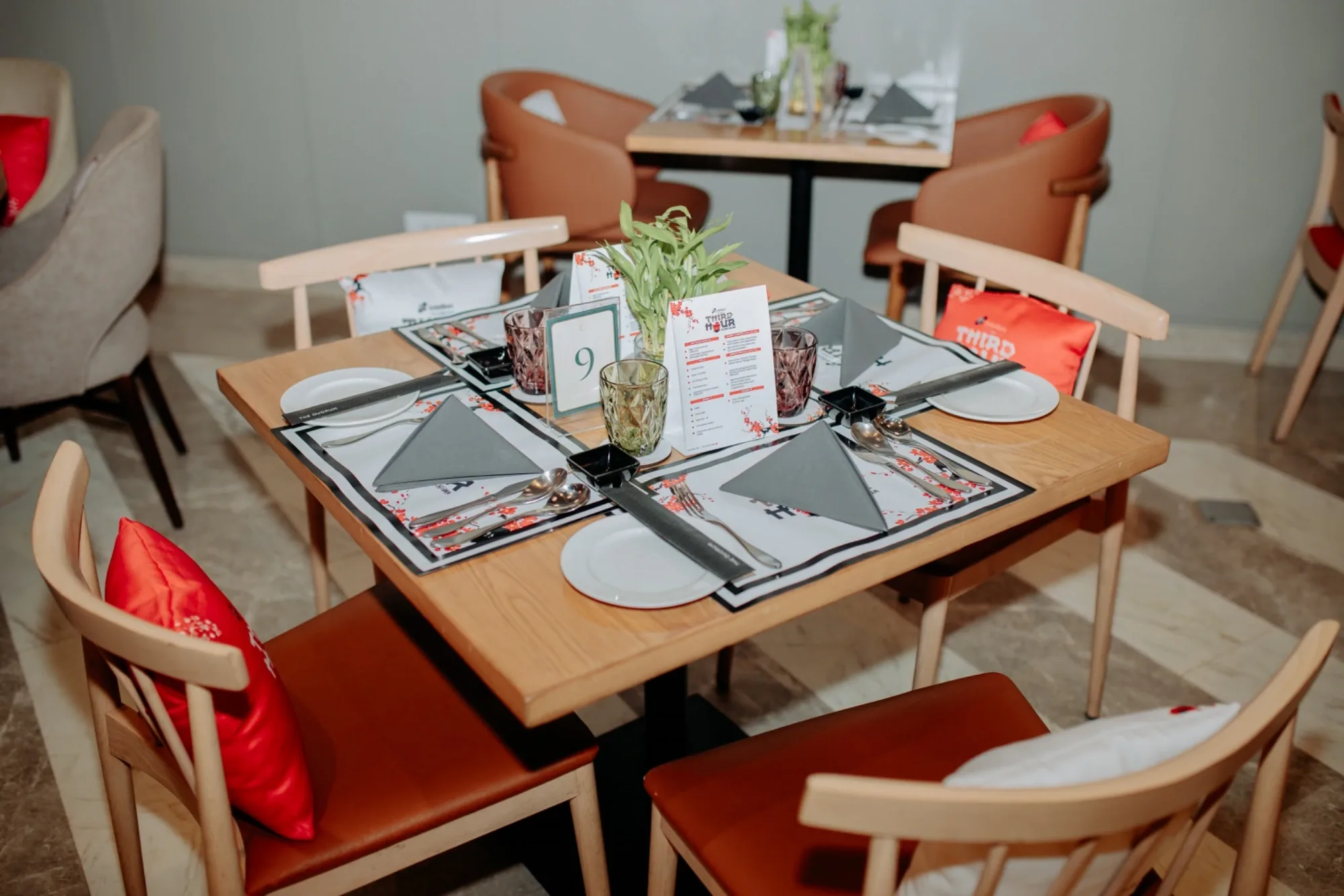 Branded tableware, menu cards and cushions at a Third Hour dinner table setting