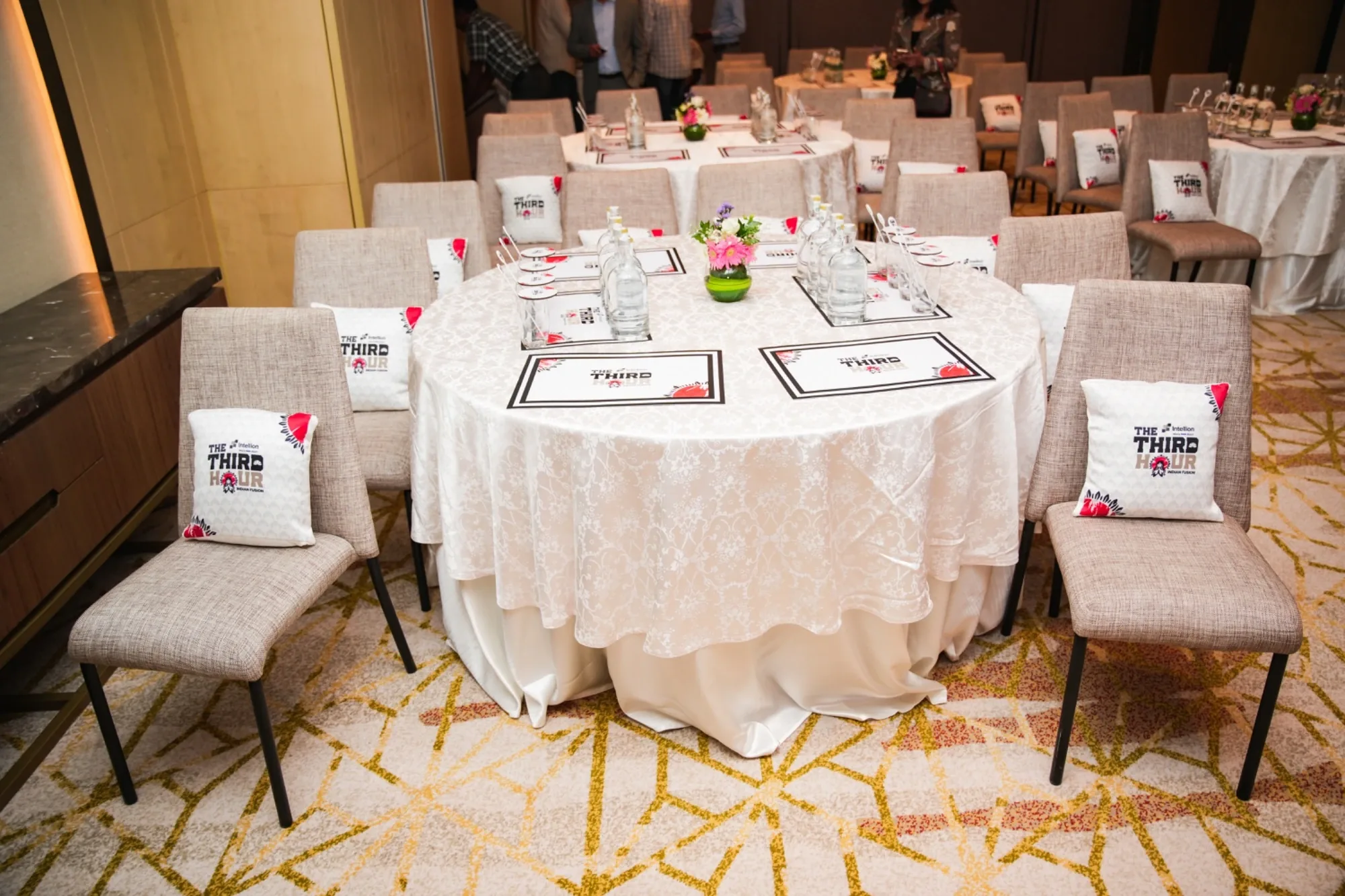 Round tables dressed with The Third Hour branded cushions and tableware