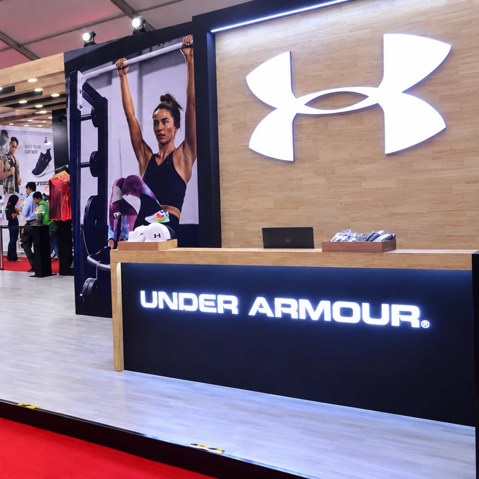 Under Armour Product Expo booth — reception desk and illuminated brand wall