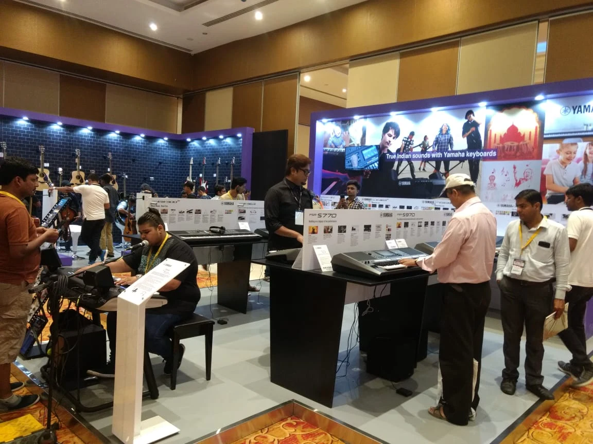 Yamaha brand experience exhibition — keyboard and instrument showcase with visitors